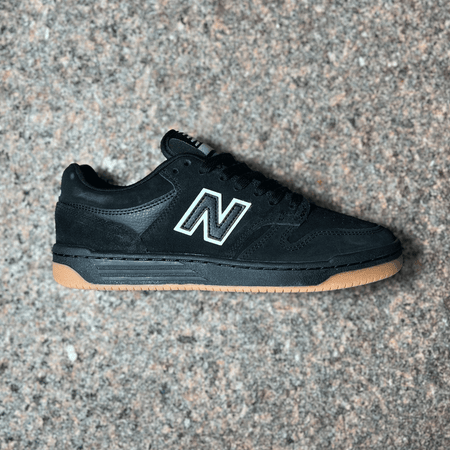 Side profile mage of right shoe.
Black suede panels with gum bottom out-sole. White outlined "N" on mid panel. 