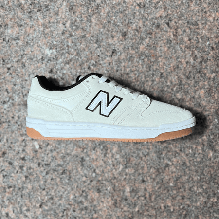 SIDE PROFILE IMAGE OF RIGHT SHOE.
WHITE SUEDE PANELS AND GUM BOTTOM OUTSOLE
BLACK OUTLINED "N"