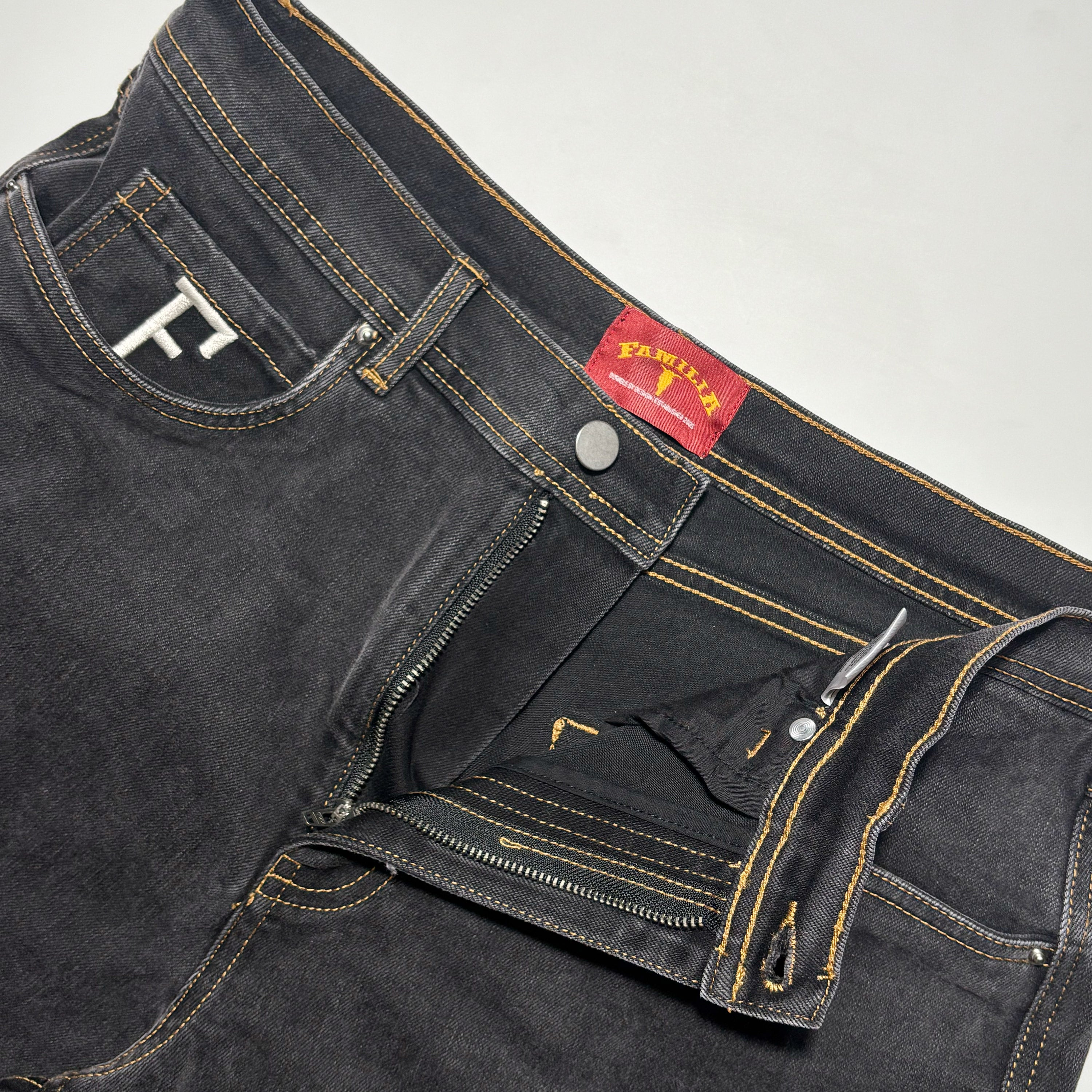 Close detail of woven label and F embroidered coin pocket.