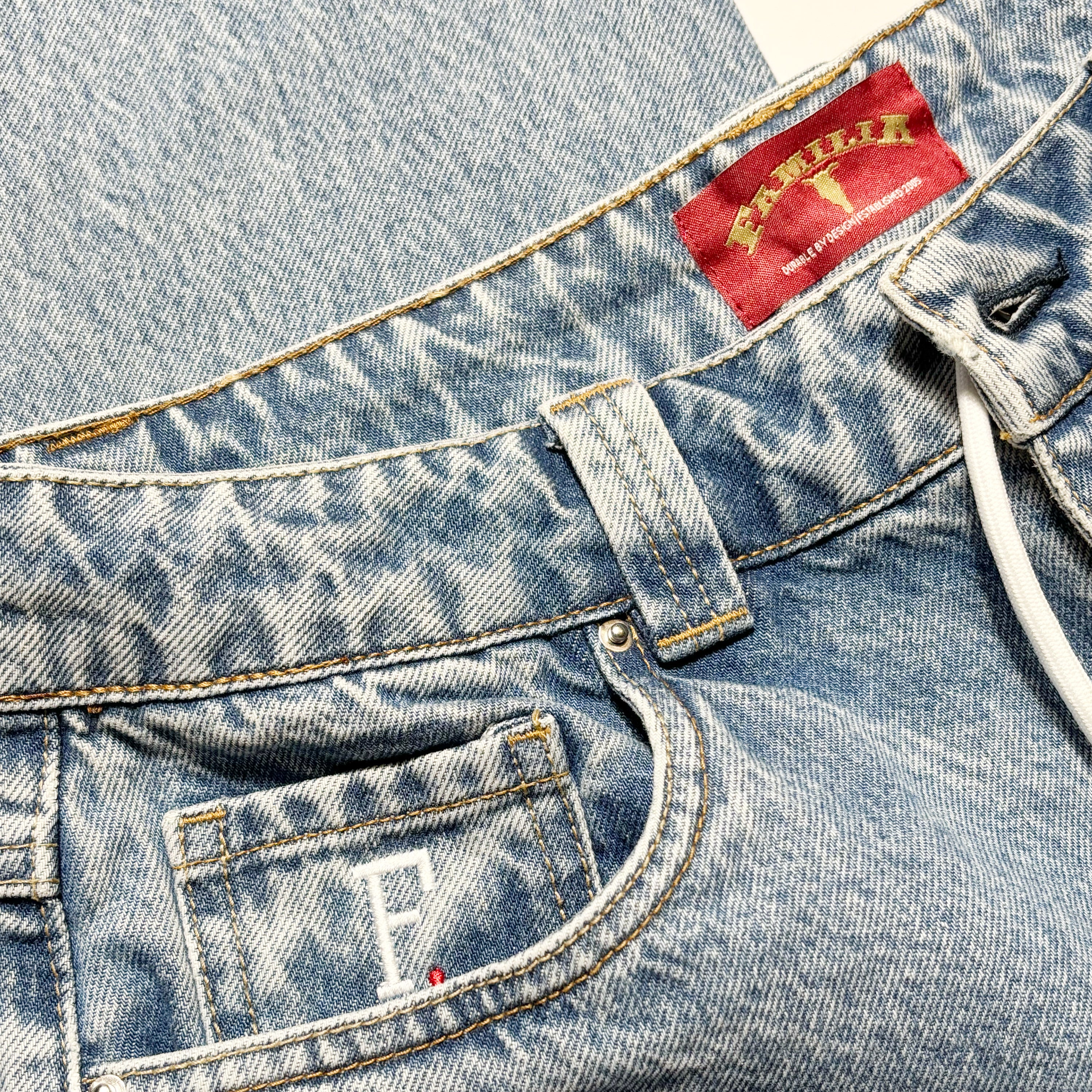 Close detail of F logo embroidered coin pocket and wash detail.