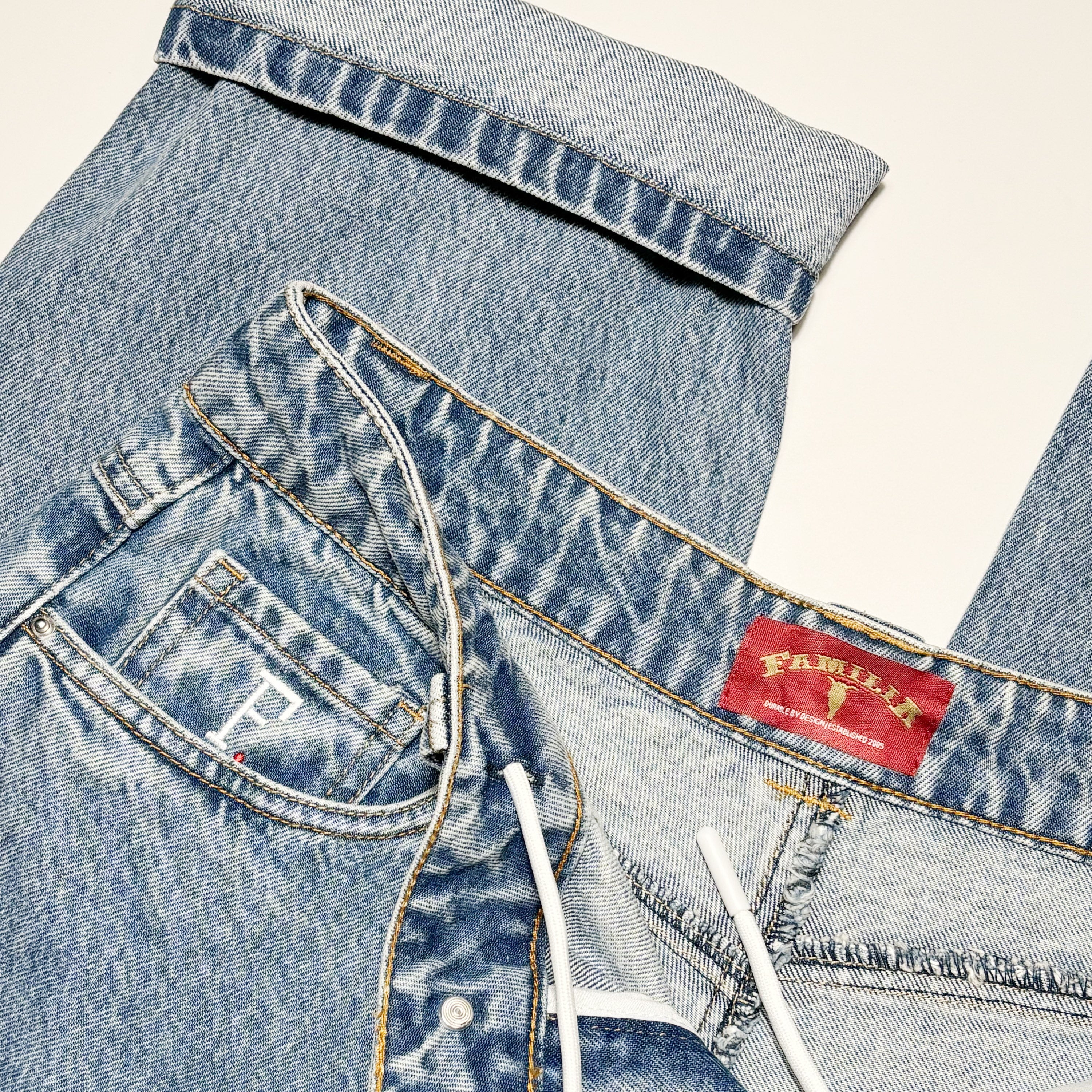 Close details of woven label inside back waistband. Embroidered coin pocket and internal drawstring.