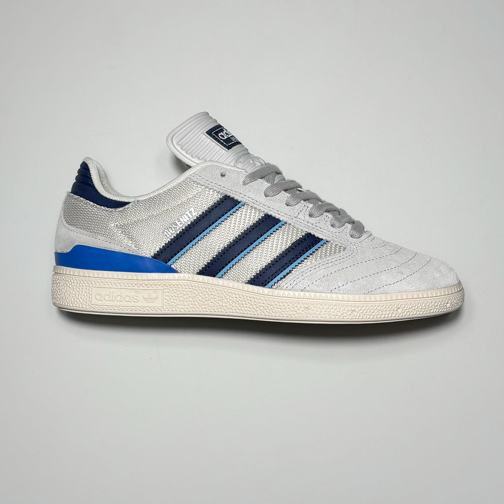 Side profile of right shoe. Grey suede with navy blue stripes.