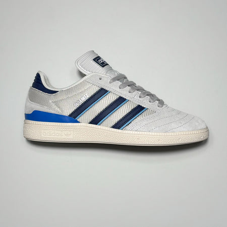 Side profile of right shoe. Grey suede with navy blue stripes.