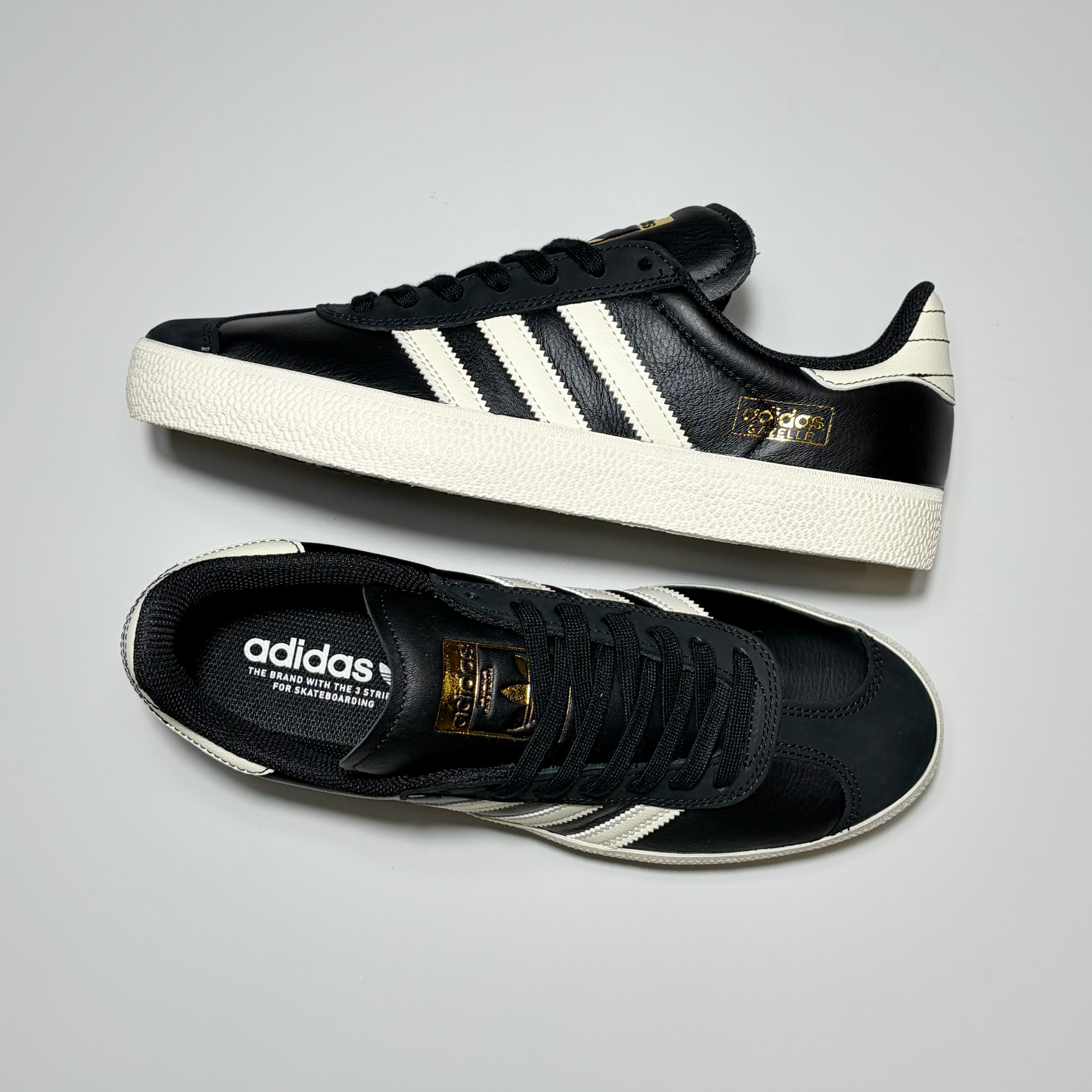 Pair of Adidas Gazelle ADV shoes on grey background.