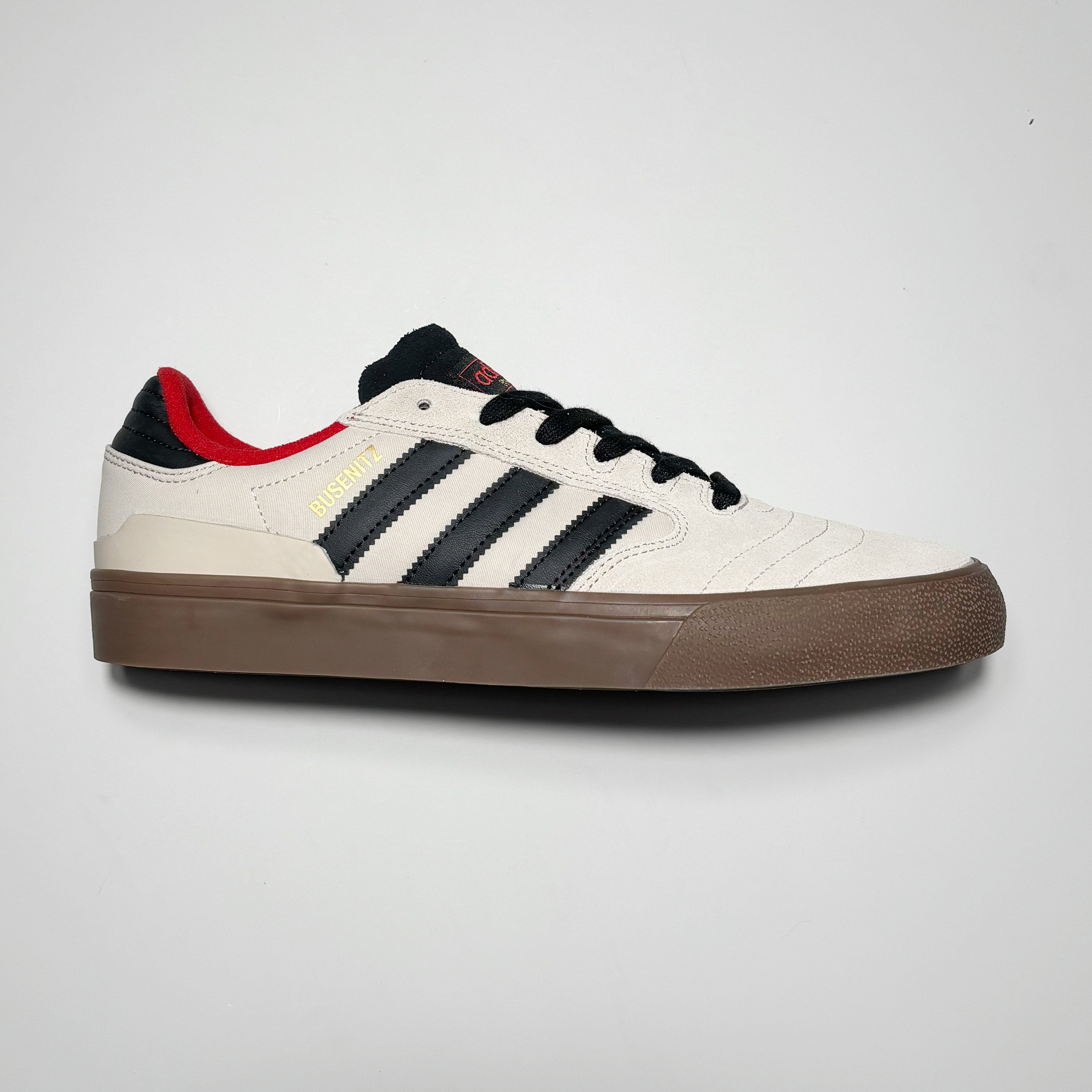 Side image of right shoe. White suede with black stripes.