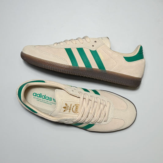 A pair of Adidas Skateboarding Samba ADV sneakers in cream suede with green stripes and a brown gum sole, displayed on a light gray background.