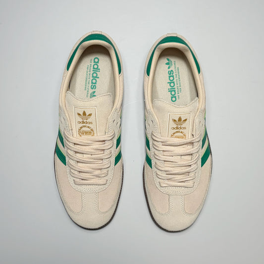 A pair of Adidas Samba ADV sneakers in cream suede and leather with green stripes and green accents, shown from a top-down view on a light gray background.