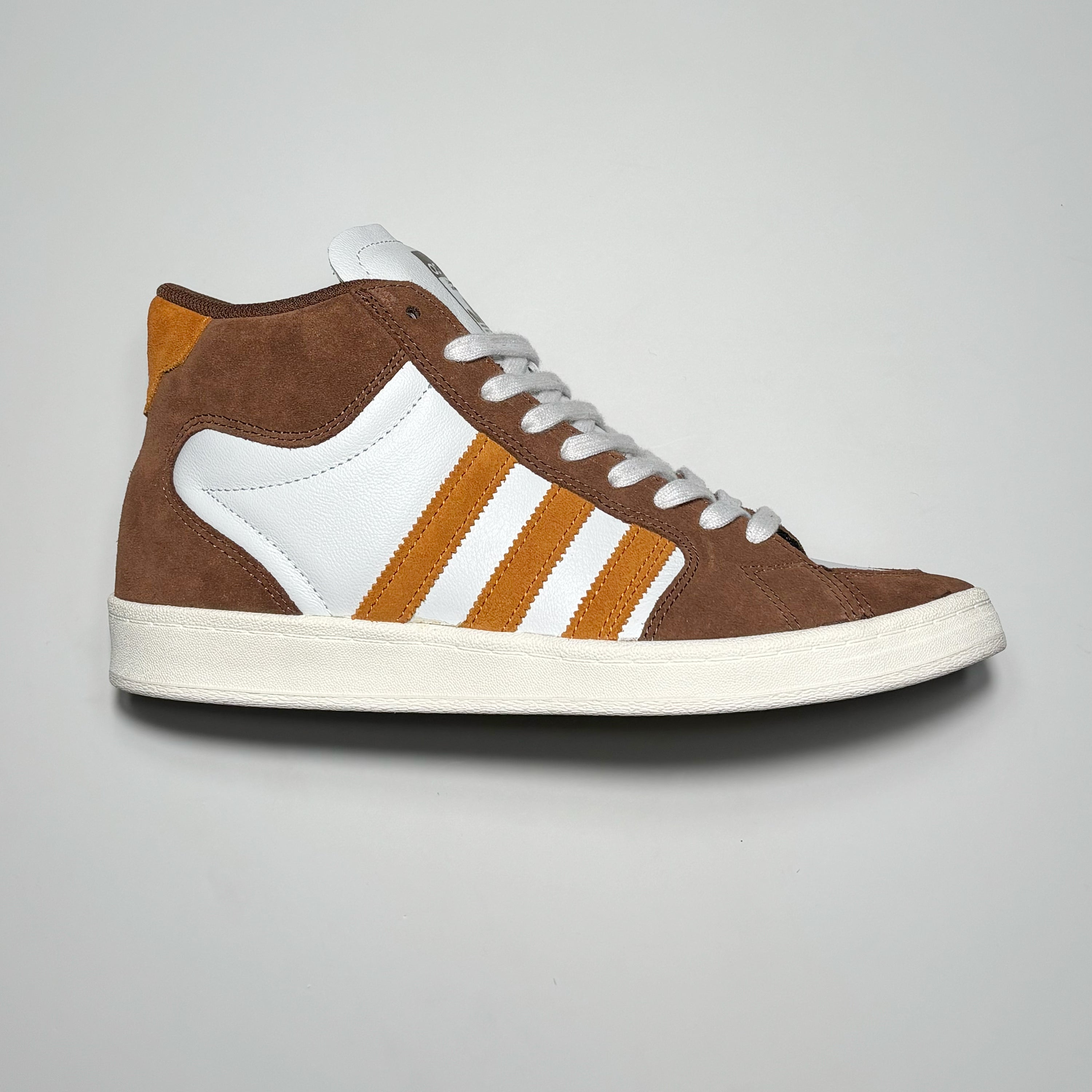 Side image of right shoe. Brown suede with orange stripes on white leather mid-panel