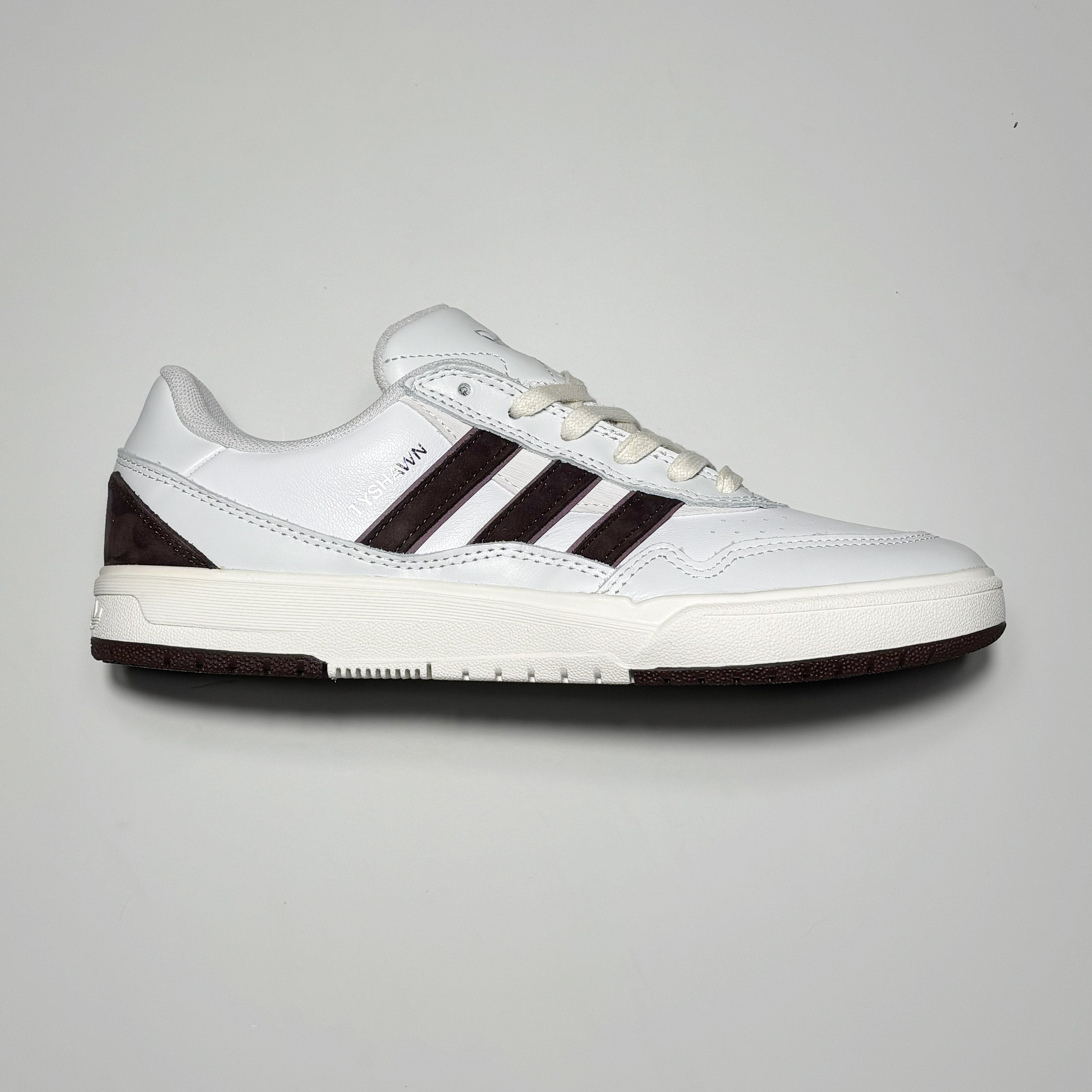 Side image of right shoe. White leather with shadow brown stripes.