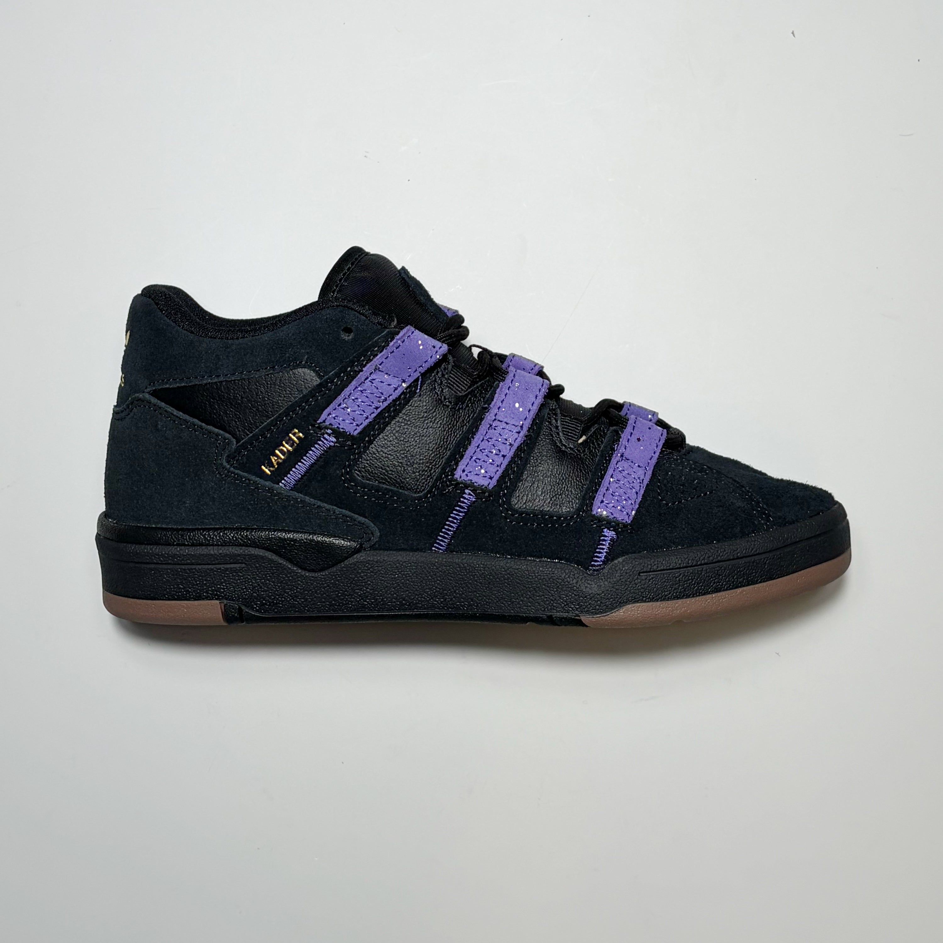 Right side image of Adidas Skateboarding Kader Pro model shoes. Black with purple stripes on white background.