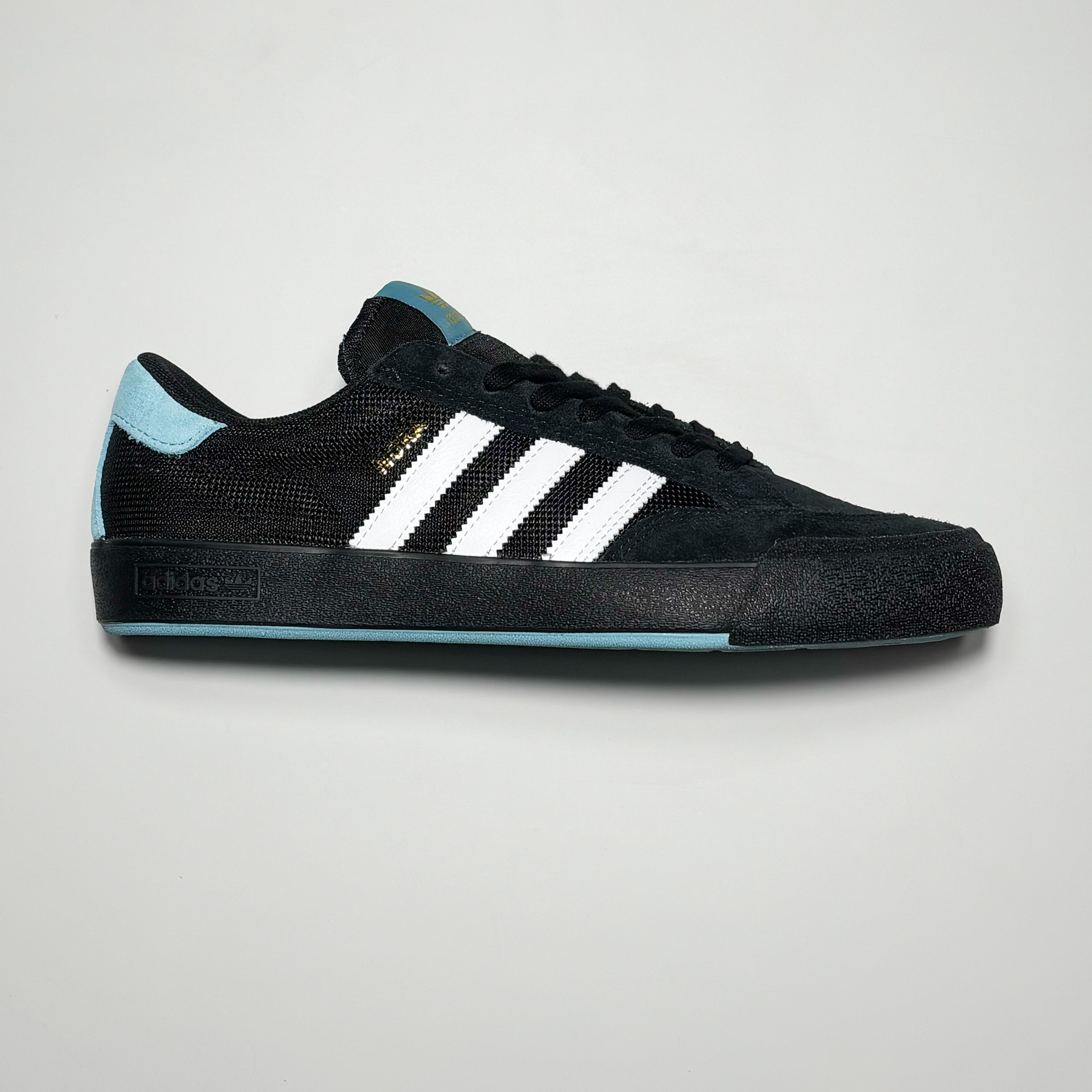 Side image of right shoe.
Black suede and midsole with white stripes.