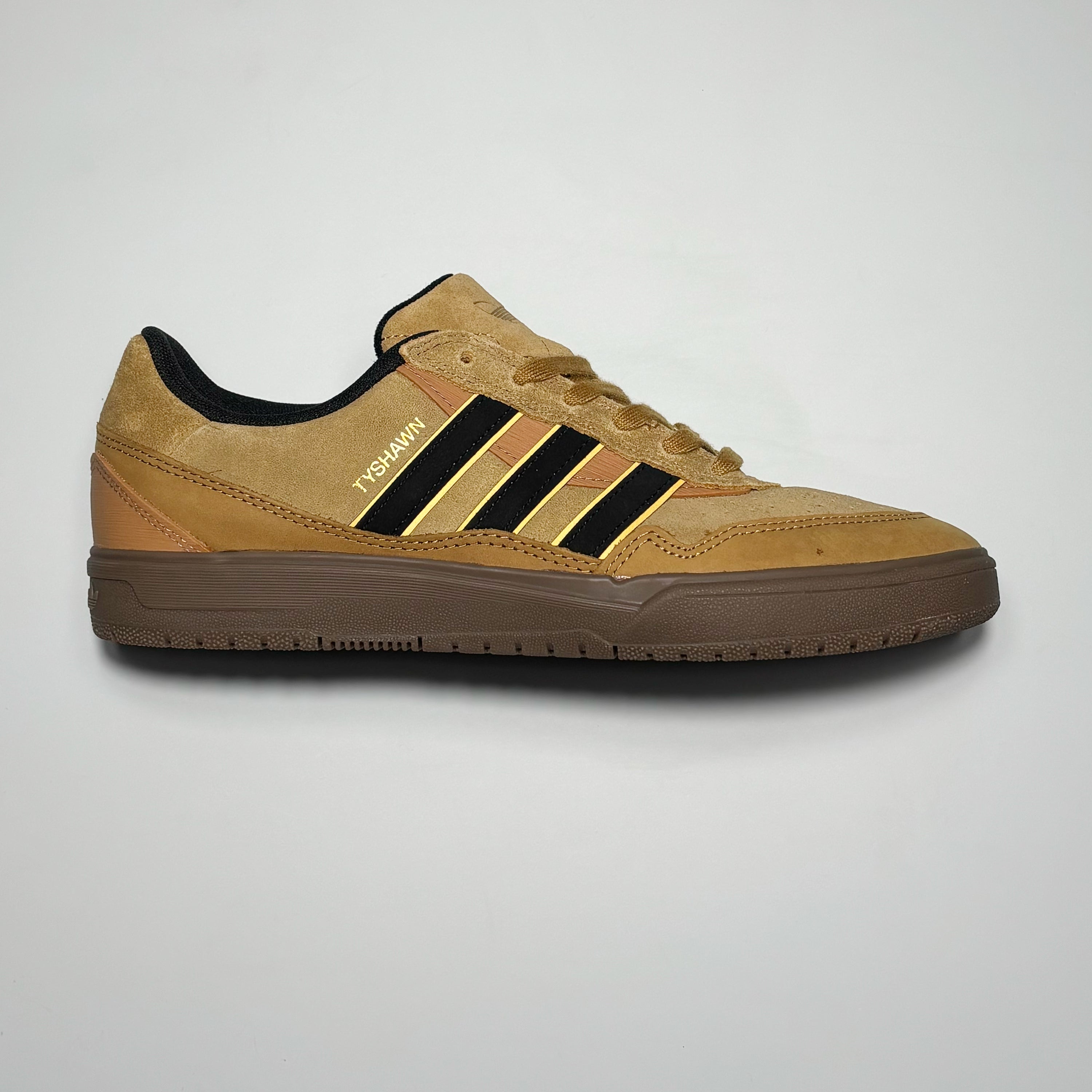 Side image of right shoe.
Light brown suede with gum outsole and black stripes.