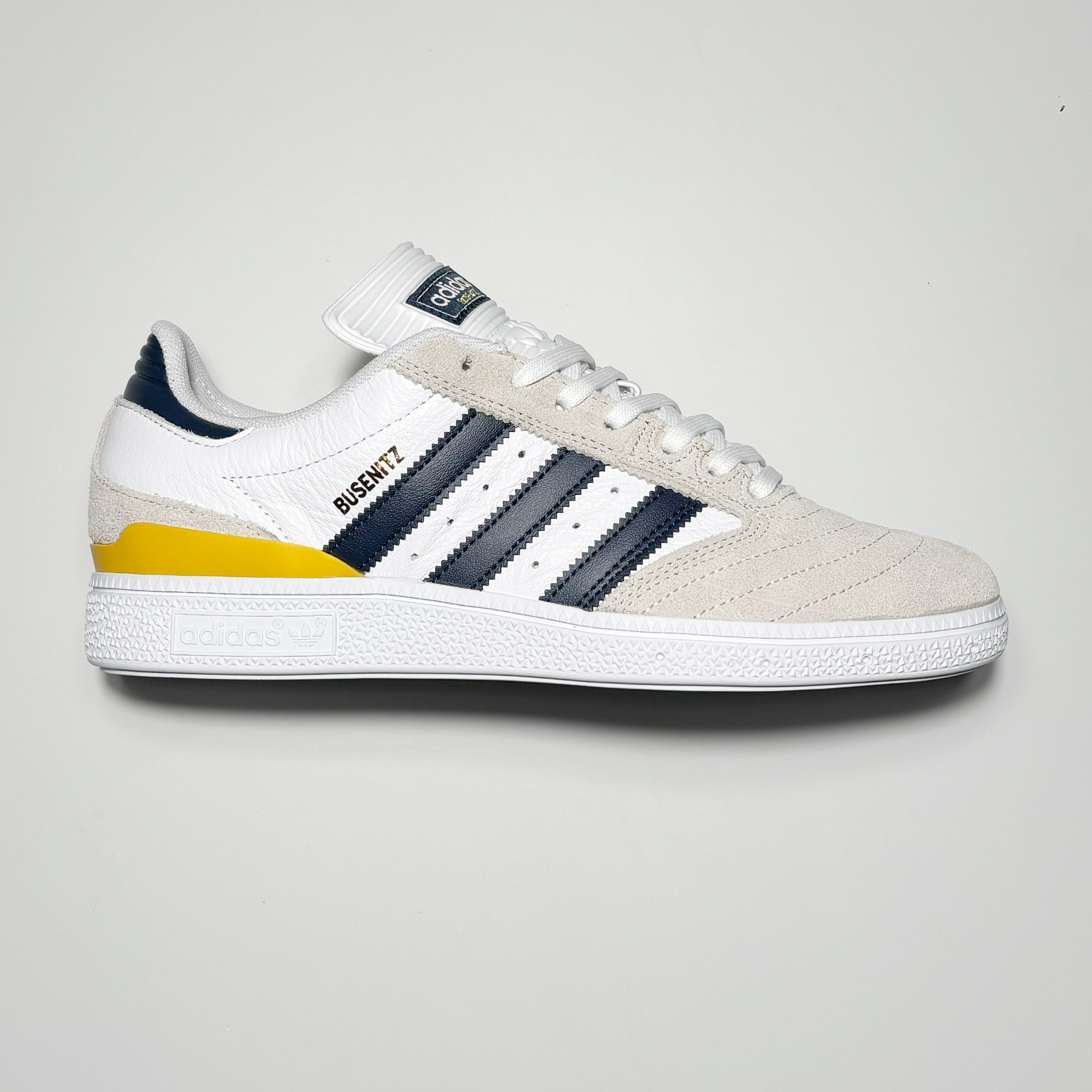 Side image of right shoe. White suede with navy stripes.