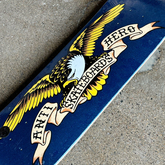 Skateboard deck with eagle design and text on a concrete surface