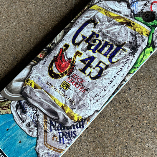 Skateboard with a crumpled can of beer labeled '45' on a concrete surface