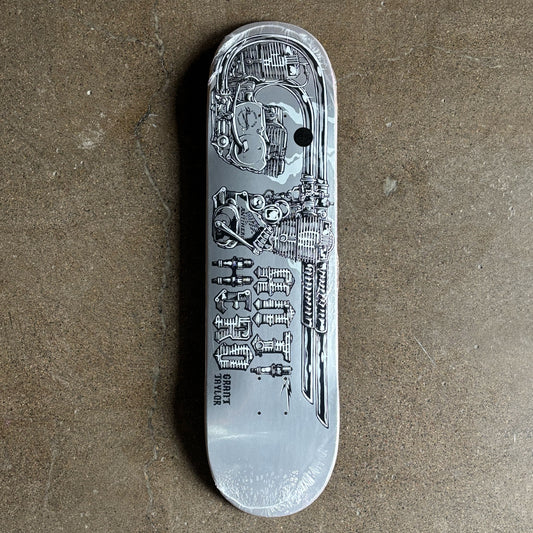 Silver skateboard deck with detailed engravings on a brown surface
