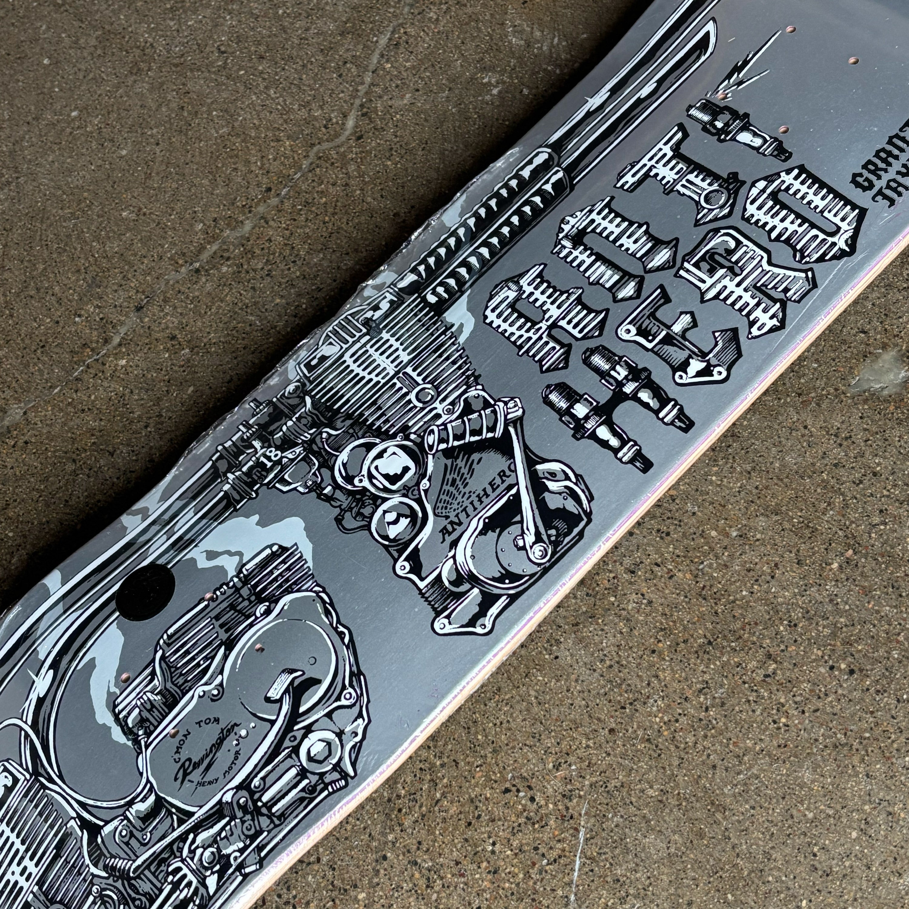 Skateboard deck with detailed mechanical design on a concrete surface