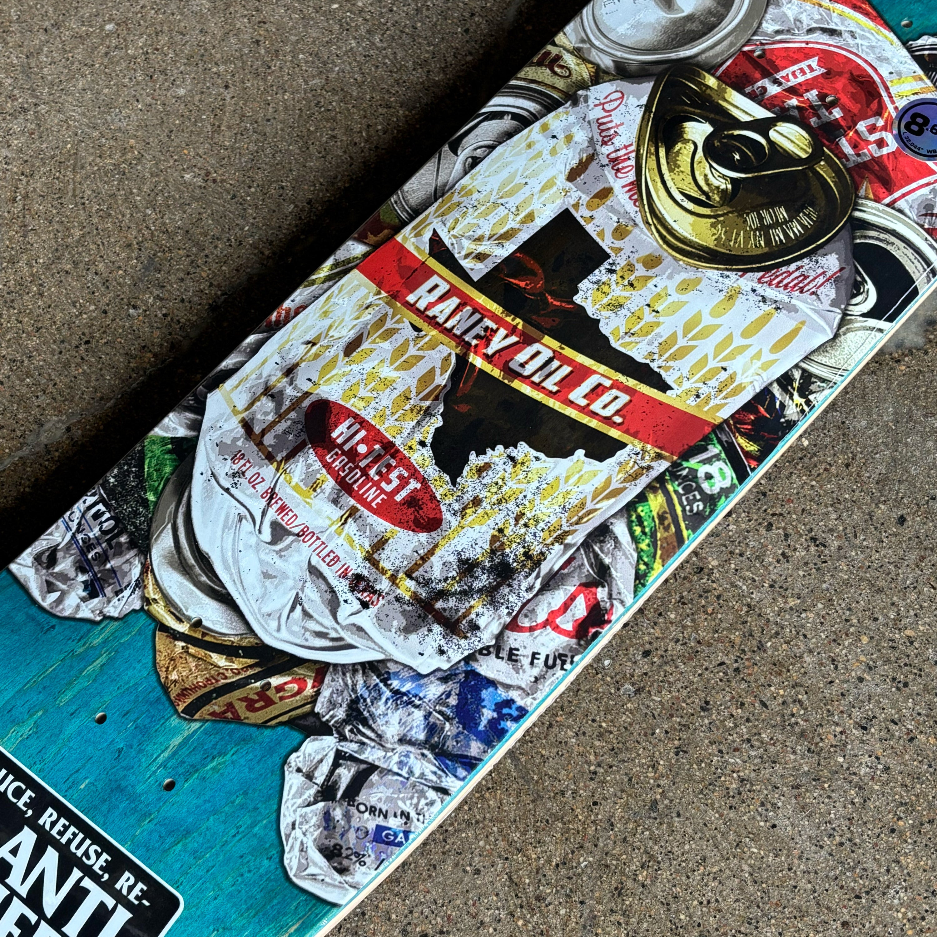 Skateboard deck with colorful graphic design on a concrete surface
