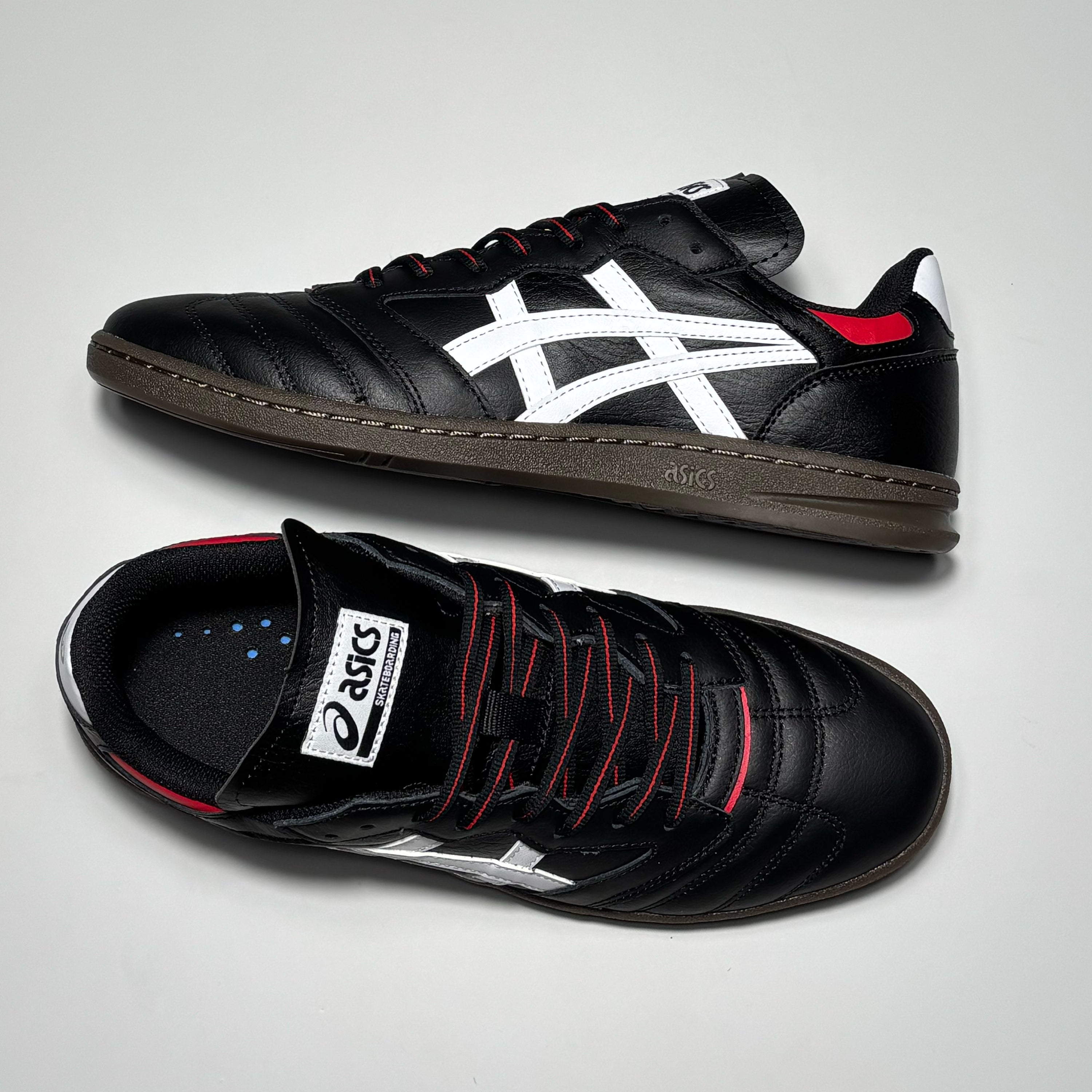 Toe down view with side profile.
Asics label on tongue and red striped black laces.