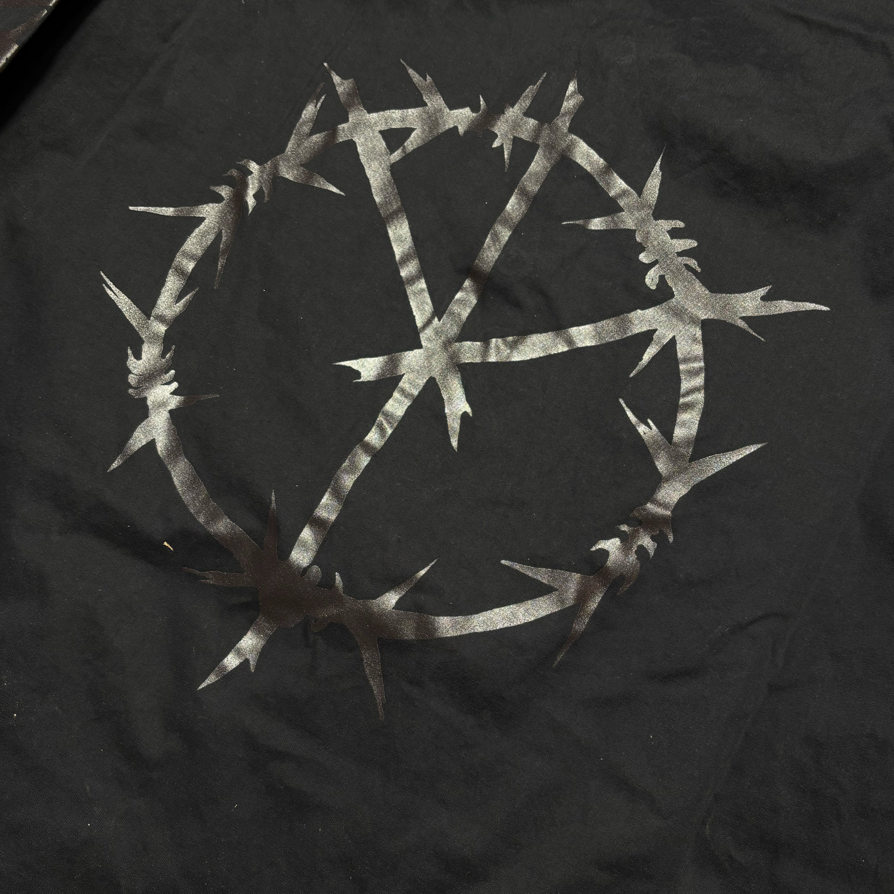 Detail of barbwire art printed on back.