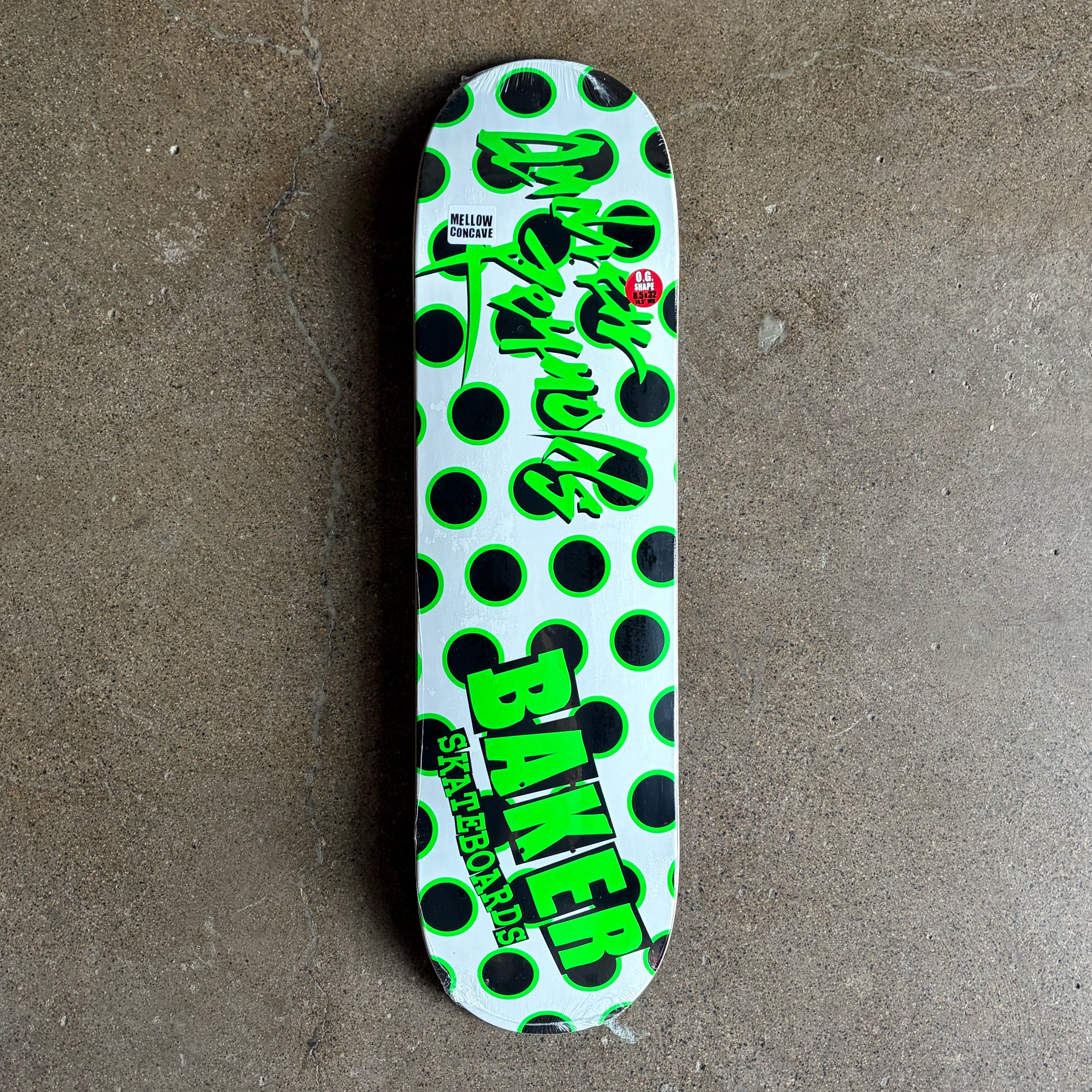 Full image of skateboard deck with Black/green dots with baker text in green.