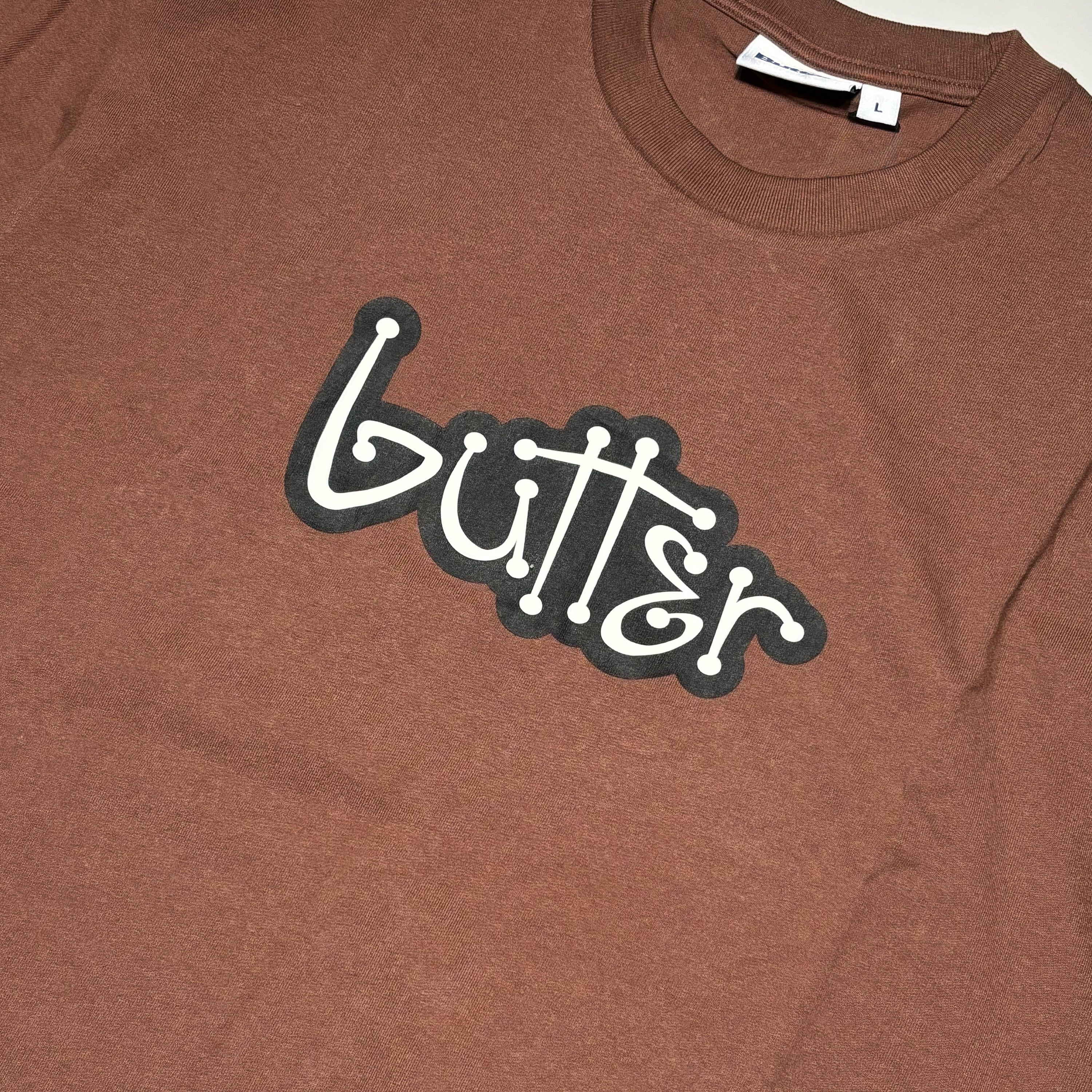 Close detail of butter logo printed on chest.