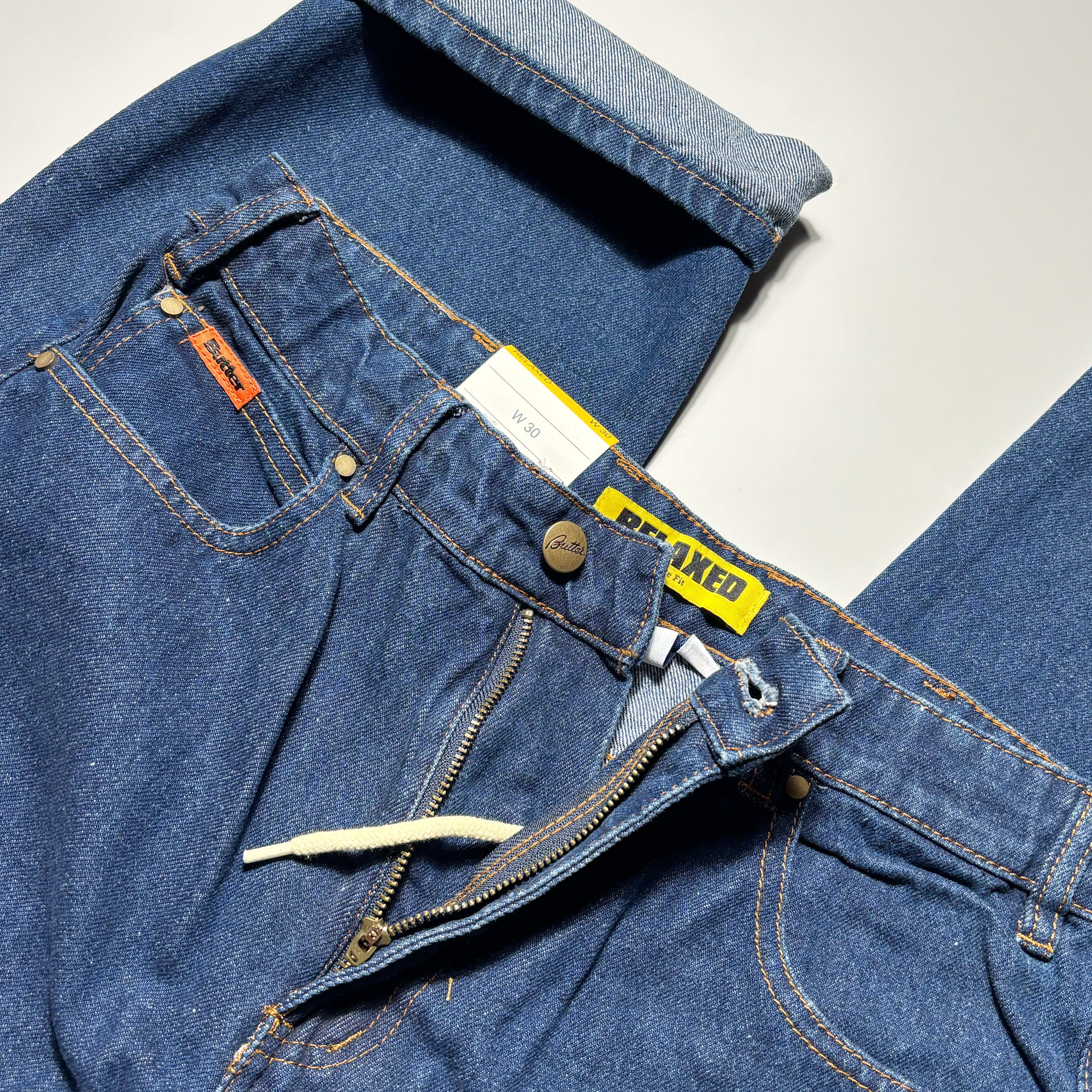 Close detail of front side of denim, zipper fly with internal drawstring.