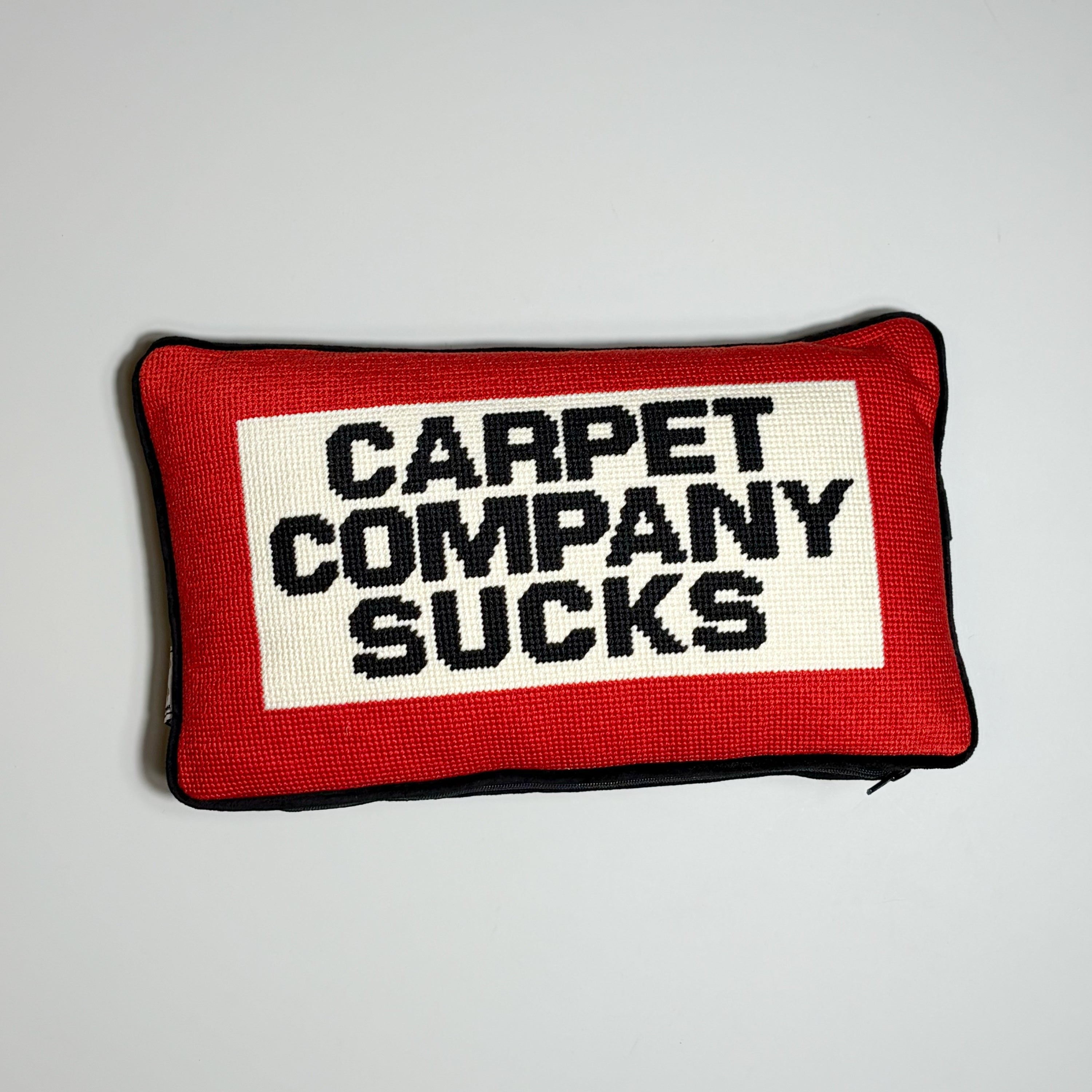 Carpet company season 22 needle point pillow. Red/white with black text "carpet company sucks" 