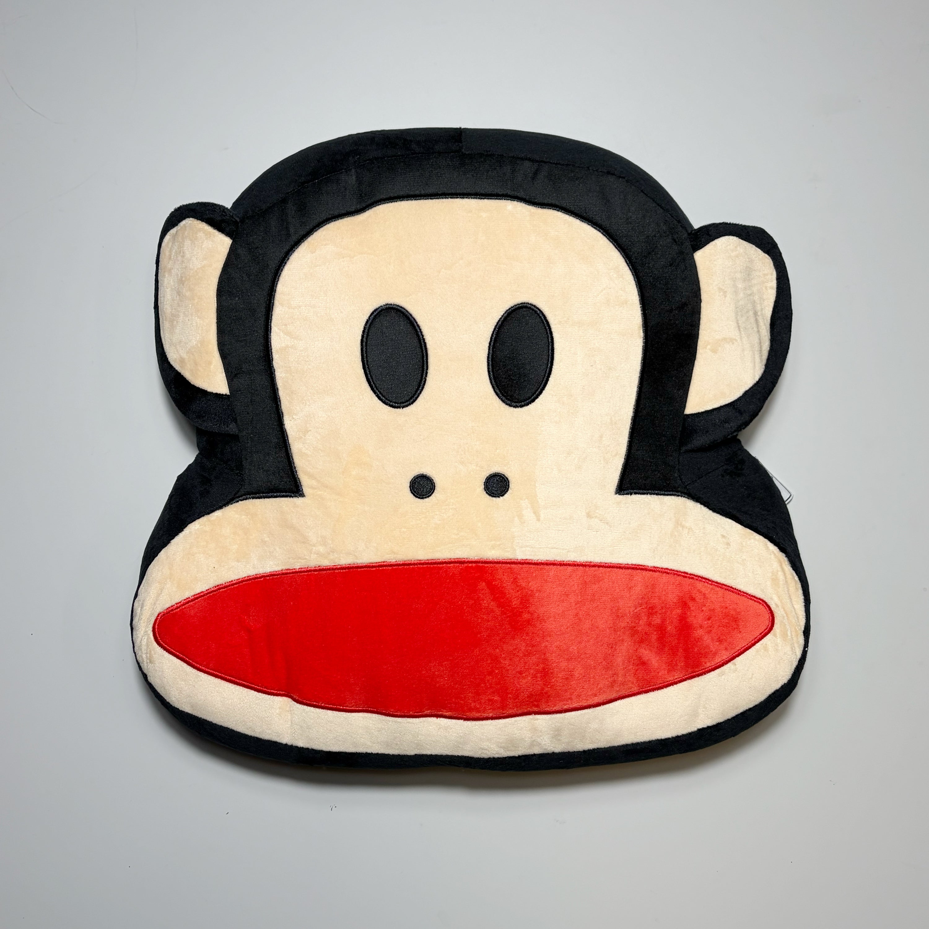Carpet Company Paul Frank Julius Monkey pillow on grey background.