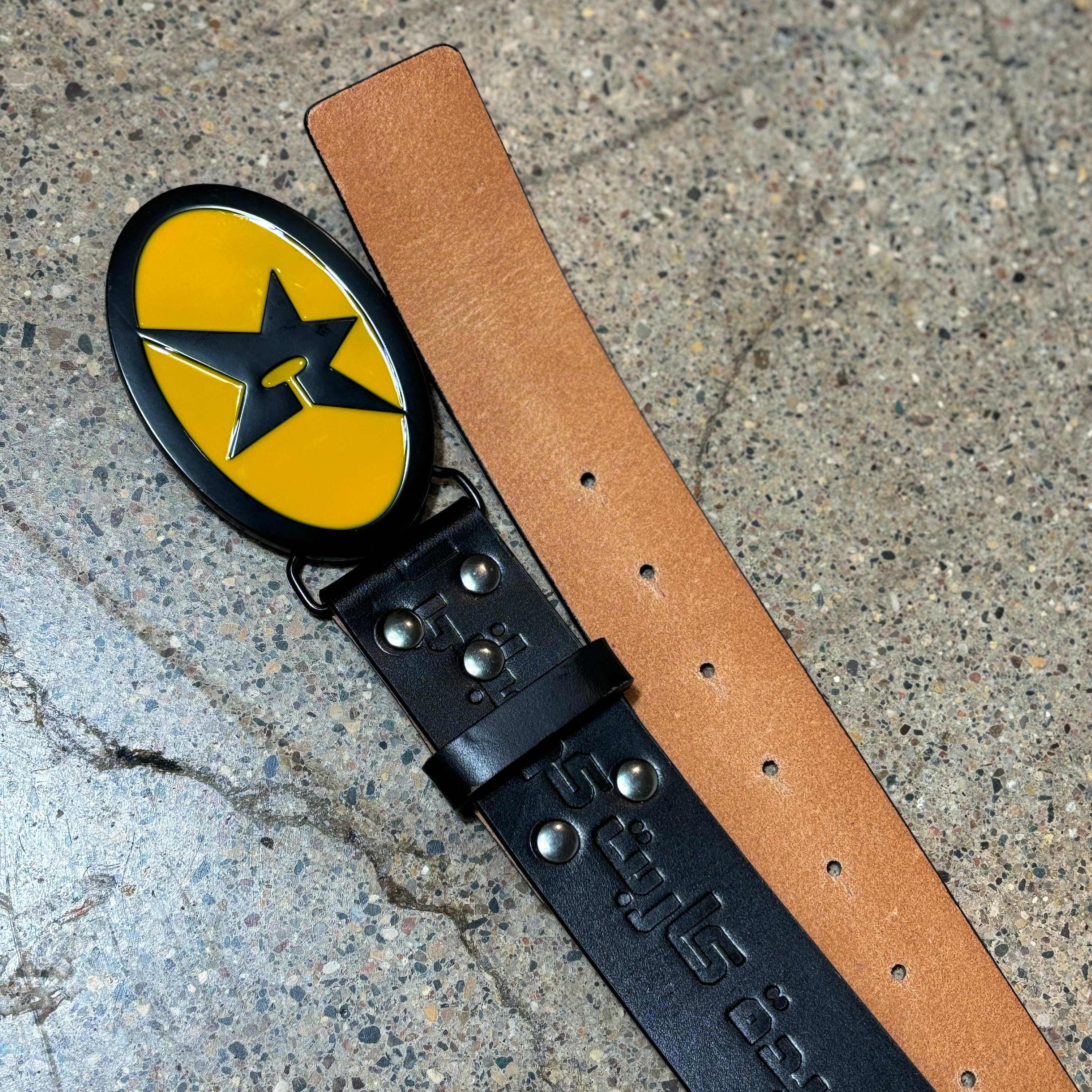 DETAIL IMAGE OF C-STAR BUCKLE AND EMBOSSED FONT ON BLACK LEATHER BELT