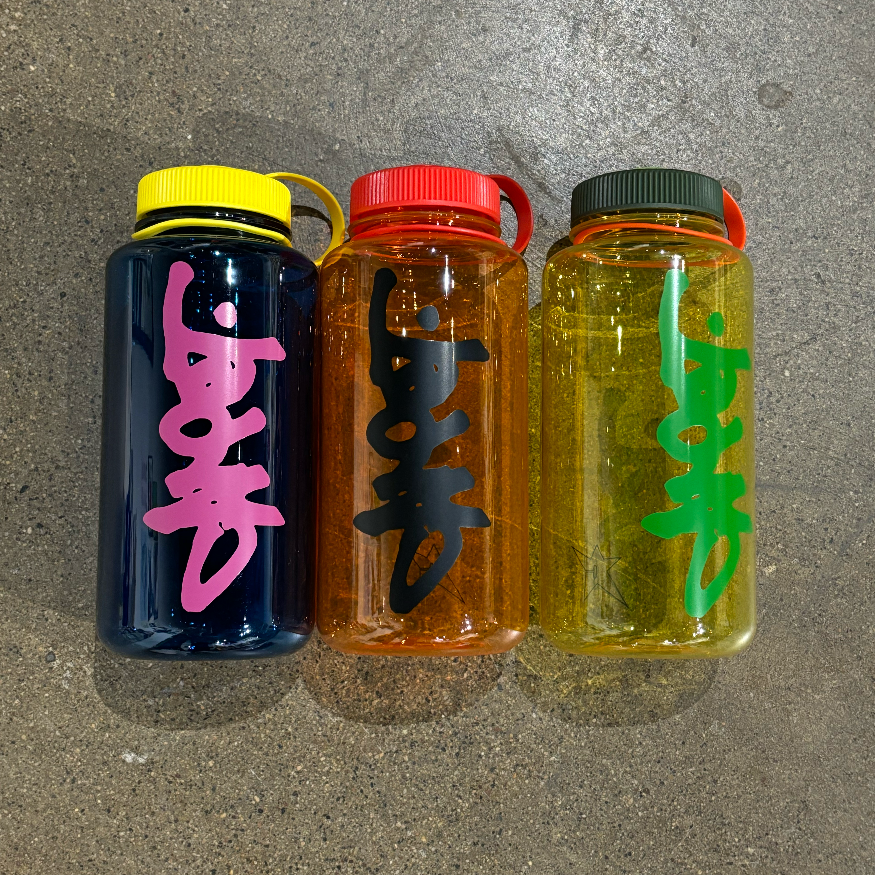 OVERALL IMAGE OF 3 COLORS OF THE SAME WATER BOTTLE. CARPET PRINTED LOGO WITH SECURE LID