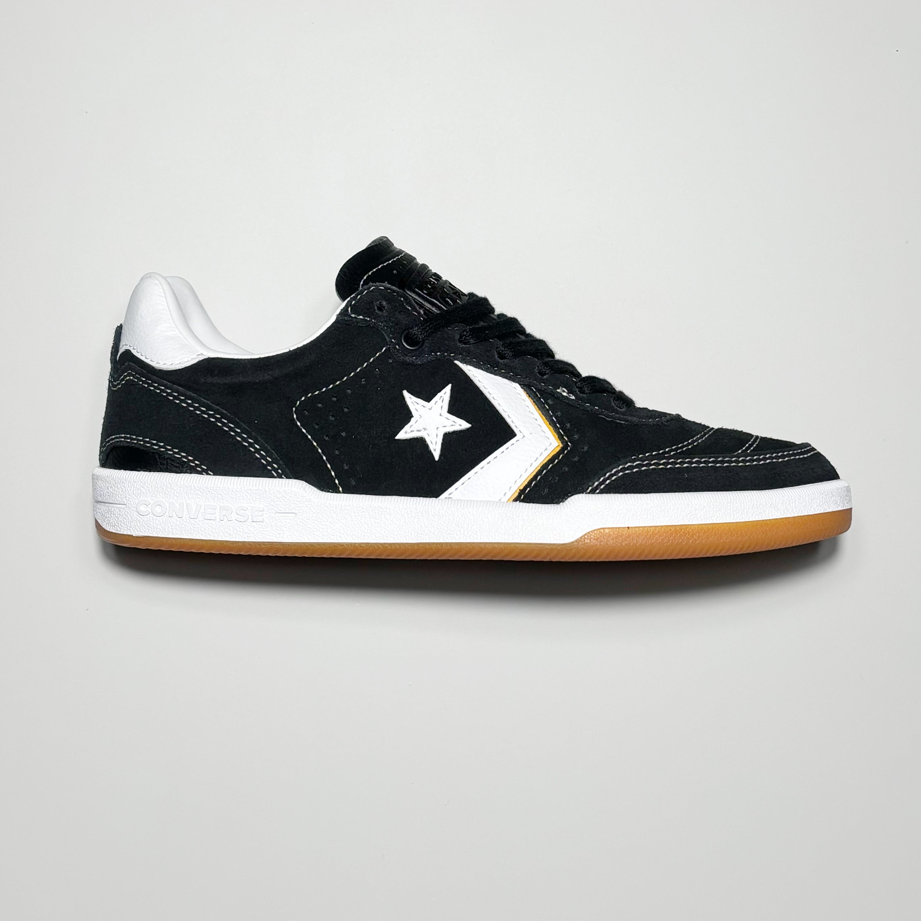 Side image of right shoe. Black suede with white chevron logo and outsole.