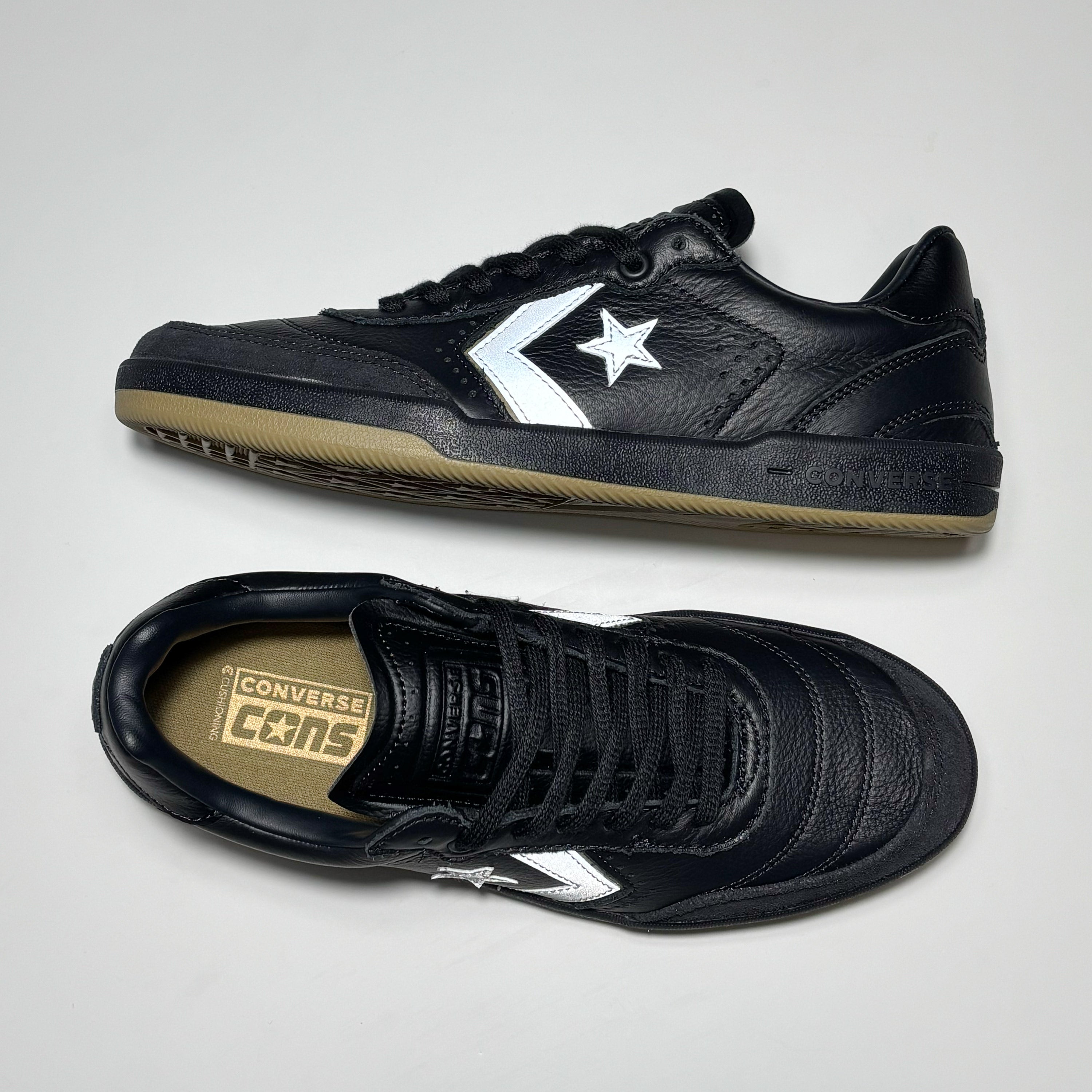 Toe down view with side profile. CONS embossed branding on tongue.