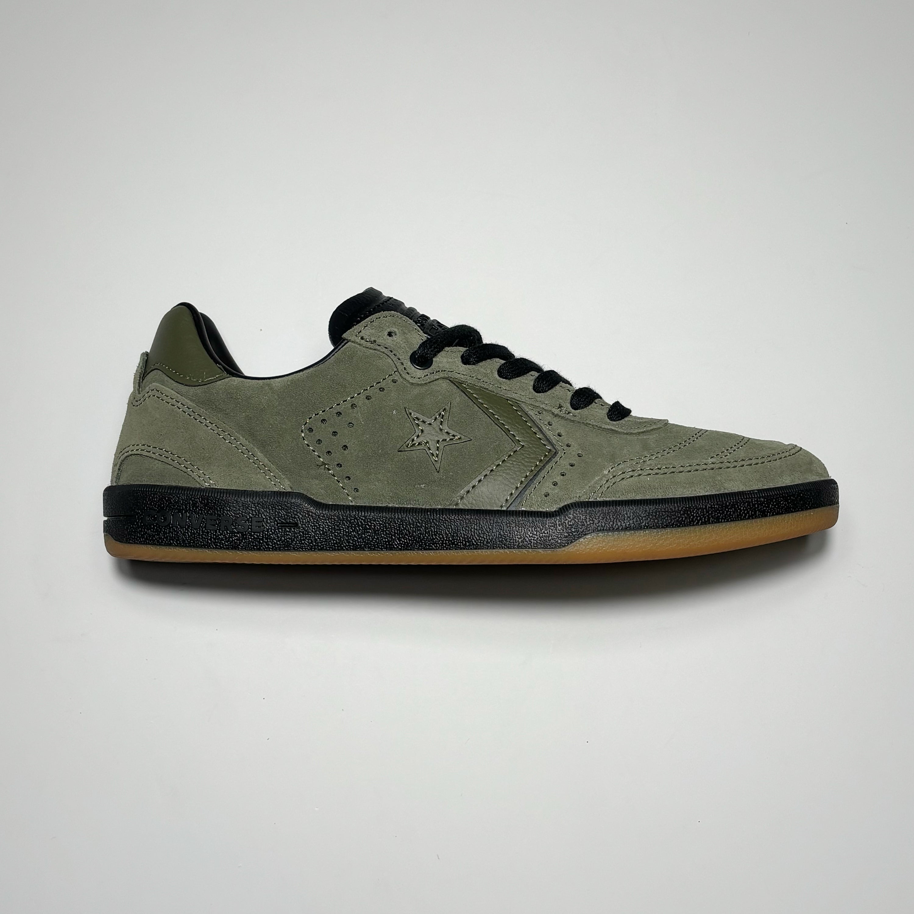 Side image of right shoe. Utility green suede with black mid-sole. 