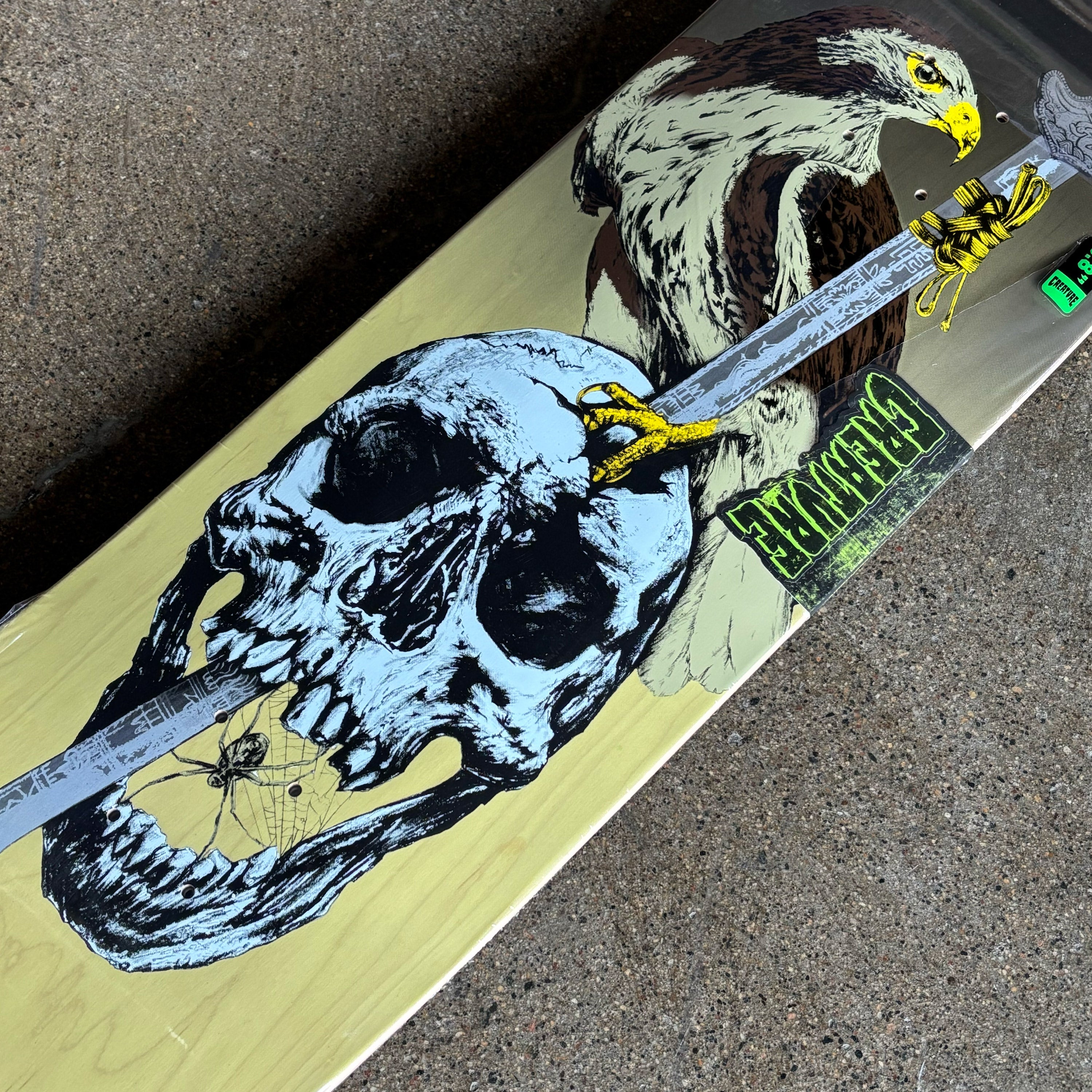 Skateboard with skull and eagle design on a textured surface