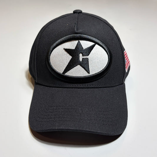 Front image of black snapback hat with c-star patch on crown. Glow in the dark oval logo. Carpet Company Season 22