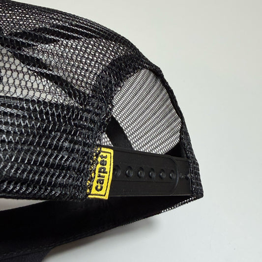 Close-up of a black mesh trucker hat showing the back strap adjustment area with a yellow and black Carhartt logo patch.