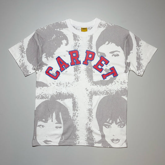 A white short-sleeve graphic t-shirt featuring a distressed gray cross design overlaid with stylized portraits of the Four Tops, with 'CARPET' printed across the chest in red letters outlined in blue.