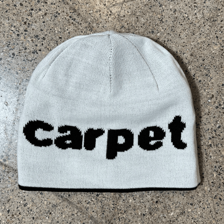 Image of reverse side of beanie.
White with black carpet font woven on side.