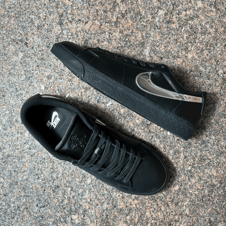 NIKE SB BLAZER LOW SHOES IN BLACK LEATHER AND BLACK SOLE WITH REFLECTIVE SWOOSH DISPLAYED ON GRANITE