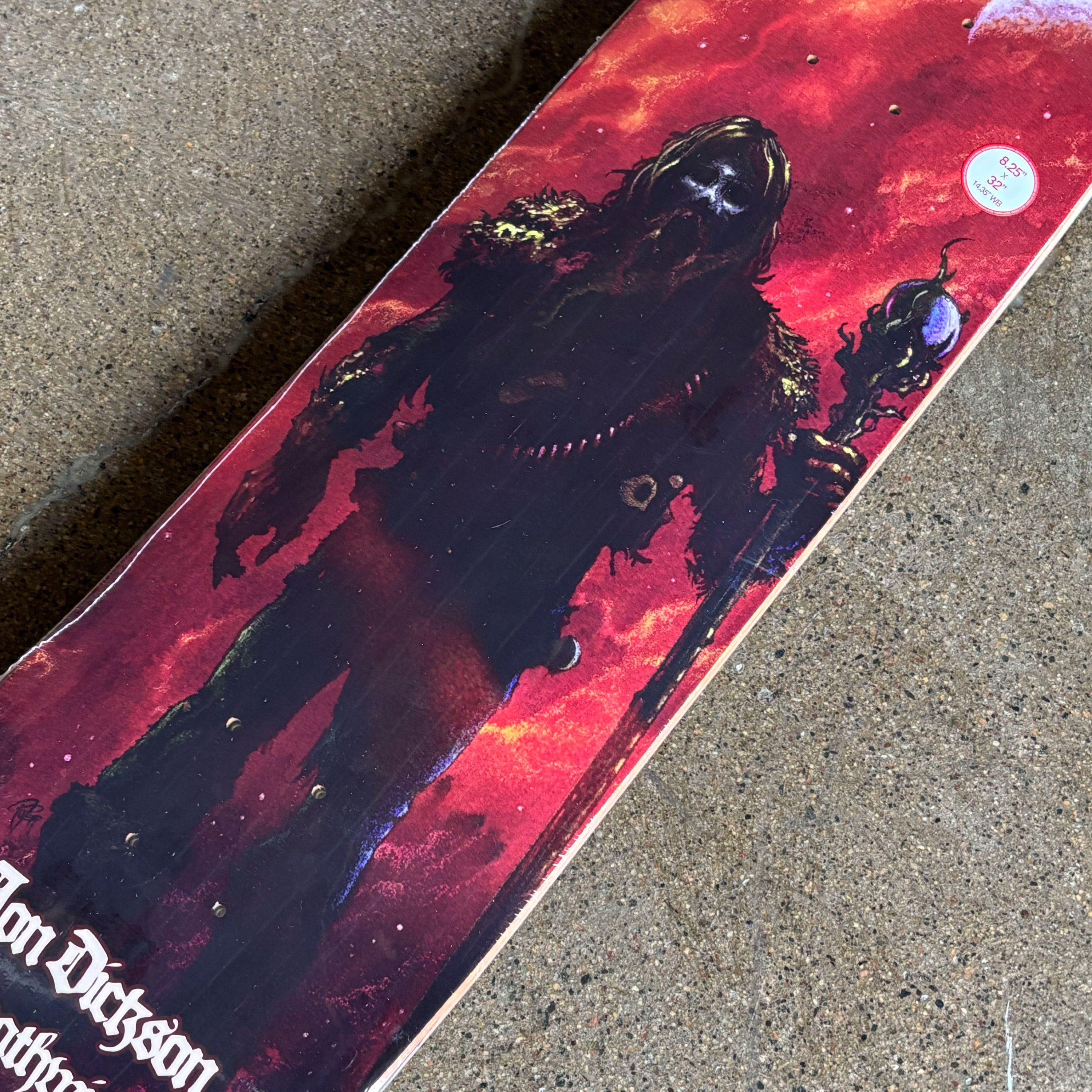 Skateboard with a red and black design on a concrete surface