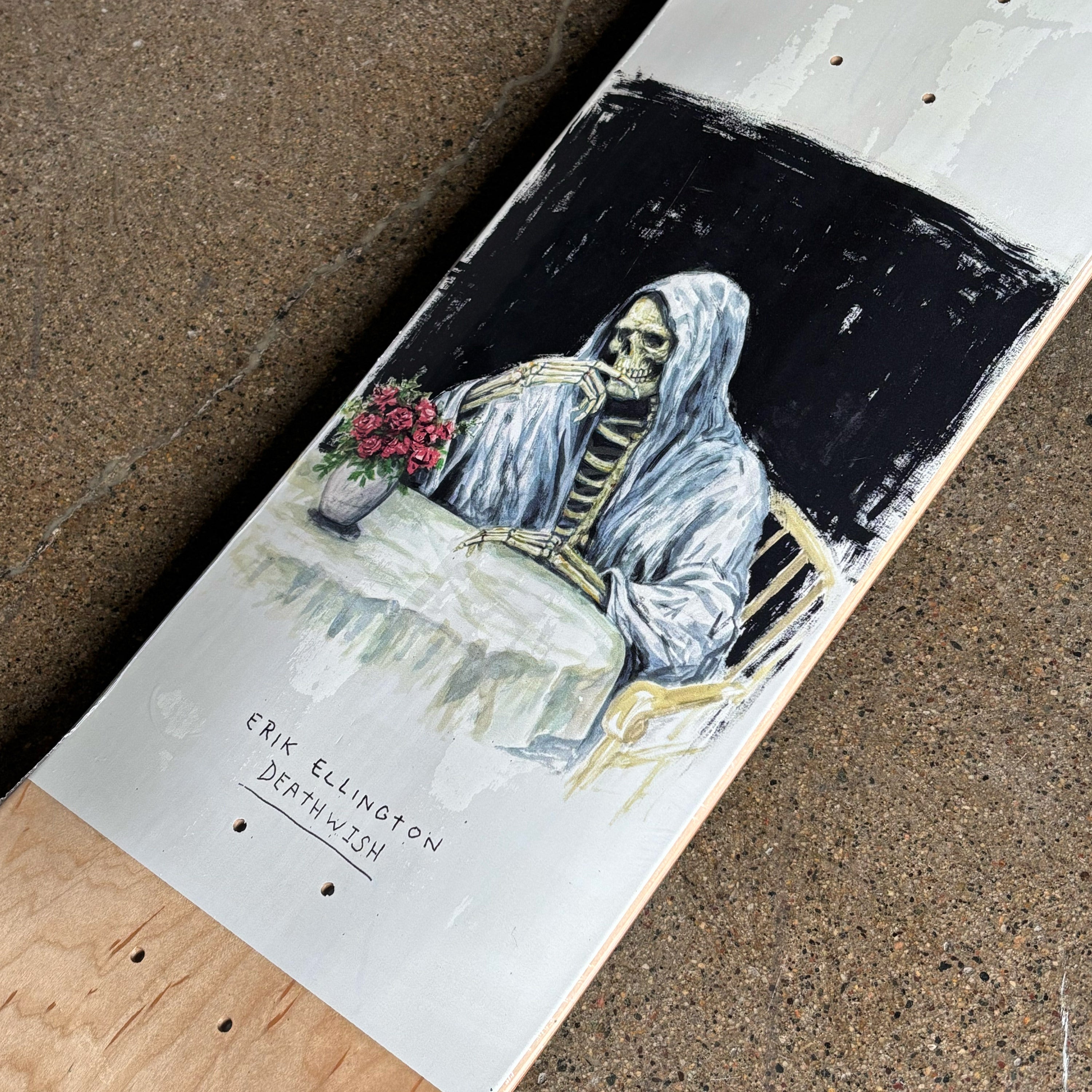 Skateboard with a skeleton holding flowers painting on a concrete surface