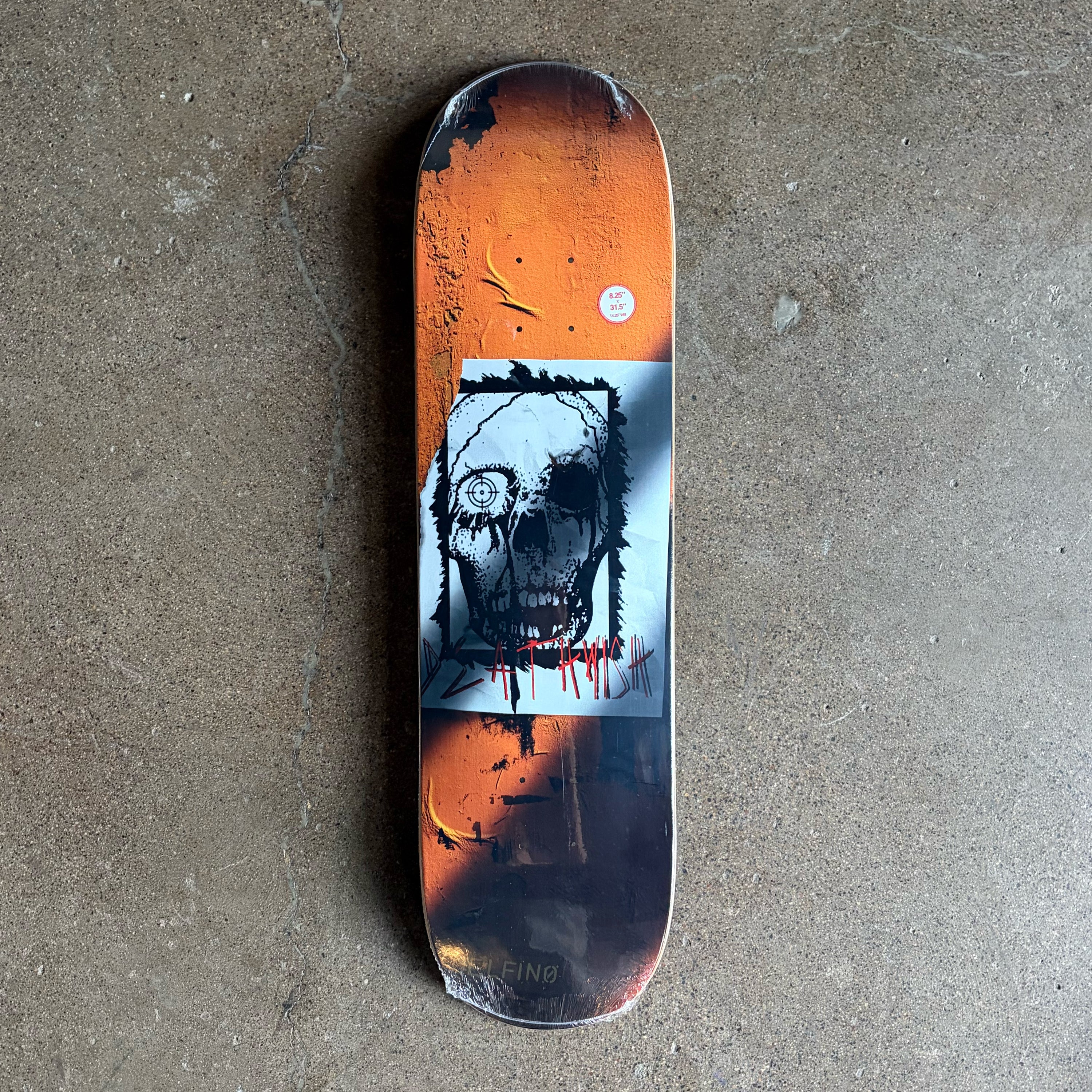 Full image of skateboard deck, black and orange stripe with skull art on board.
