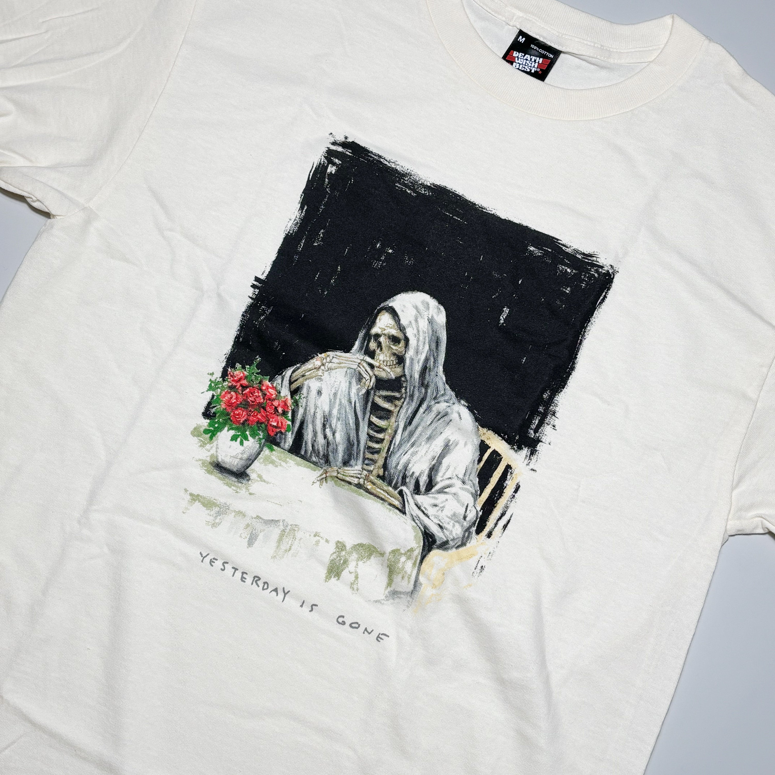 White t-shirt with a graphic of a skeleton holding flowers and text 'Yesterday is gone' on a plain background.