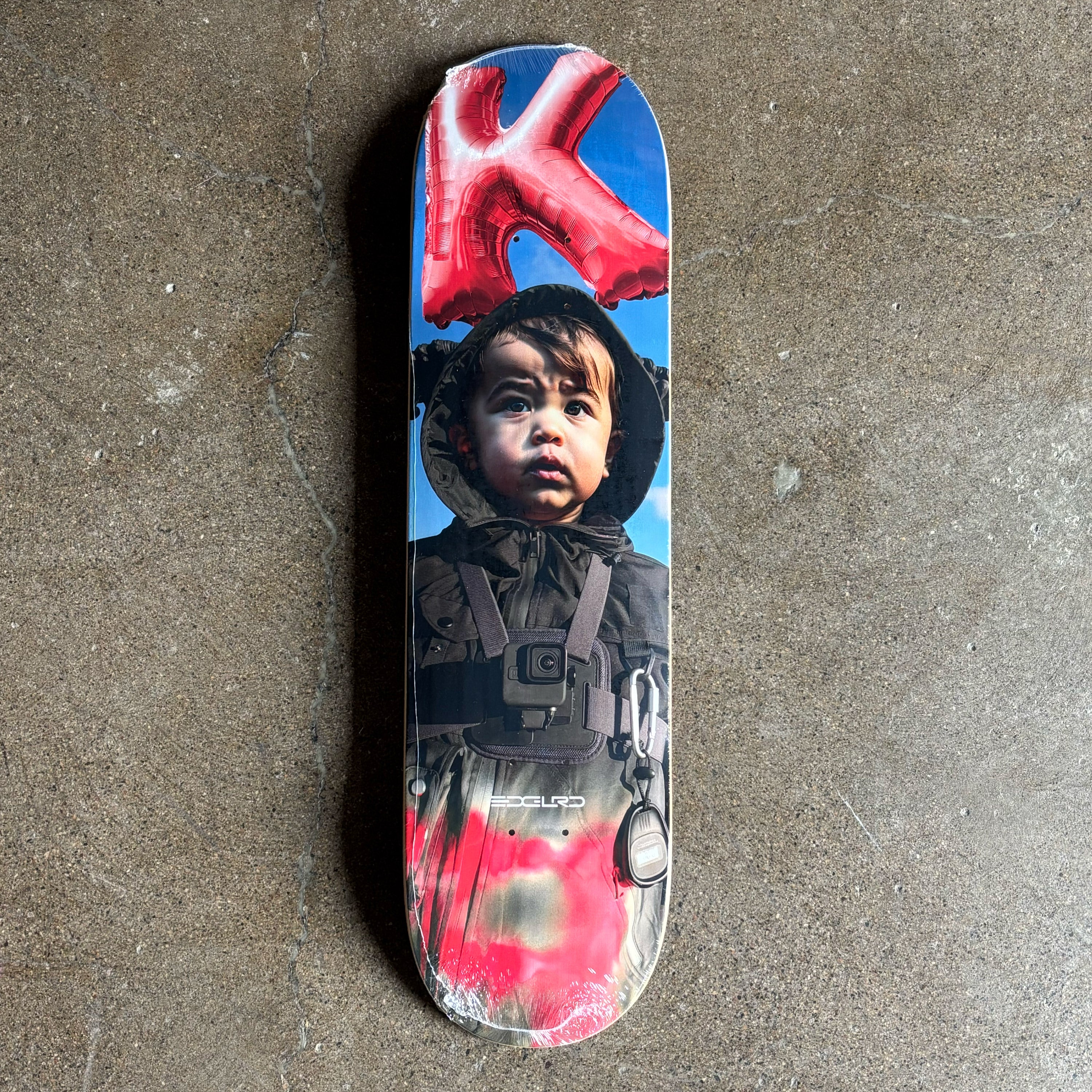 Full image of deck with a printed design of a child wearing a hooded jacket on.