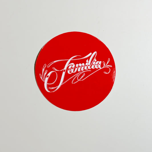 Red circular sticker with 'Familia' text on a light gray background