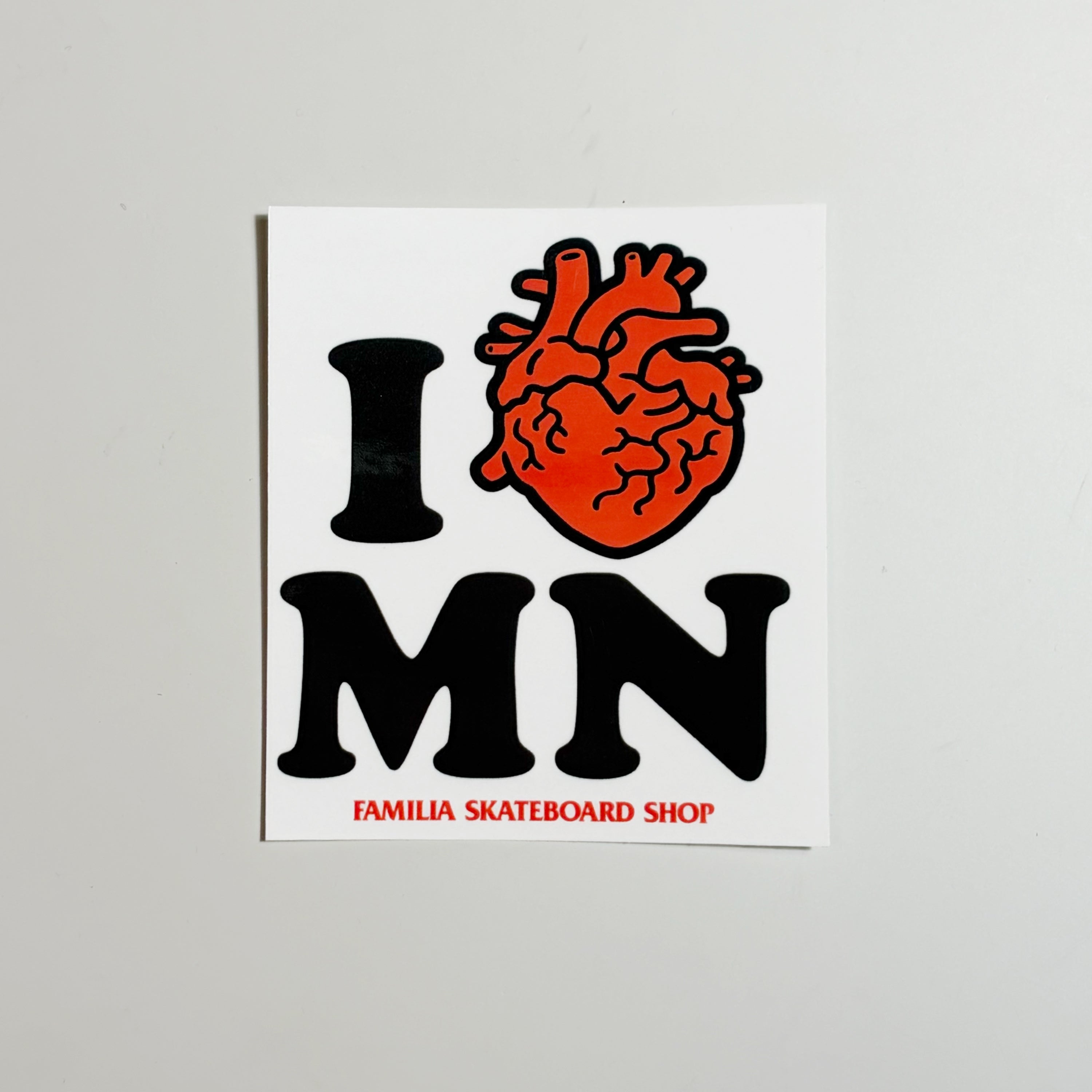 Image of white vinyl sticker with I heart MN text in black/red on a white background.
