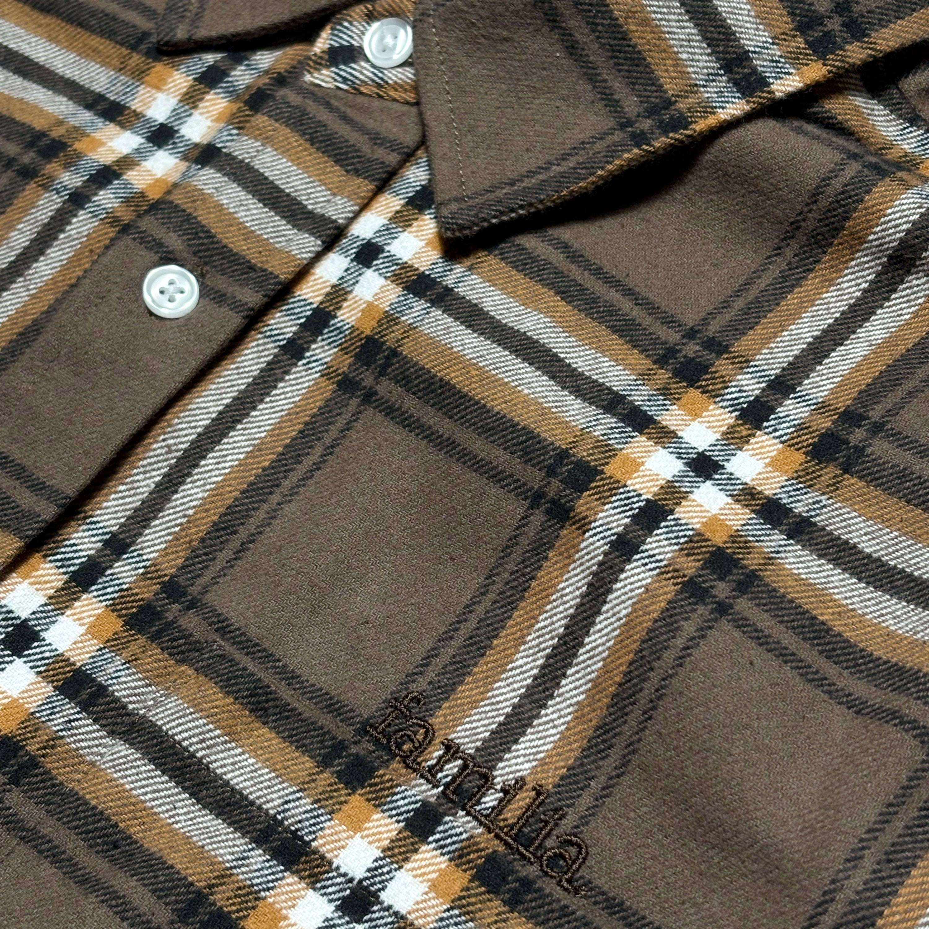 Close detail of familia embroidery above pocket. 