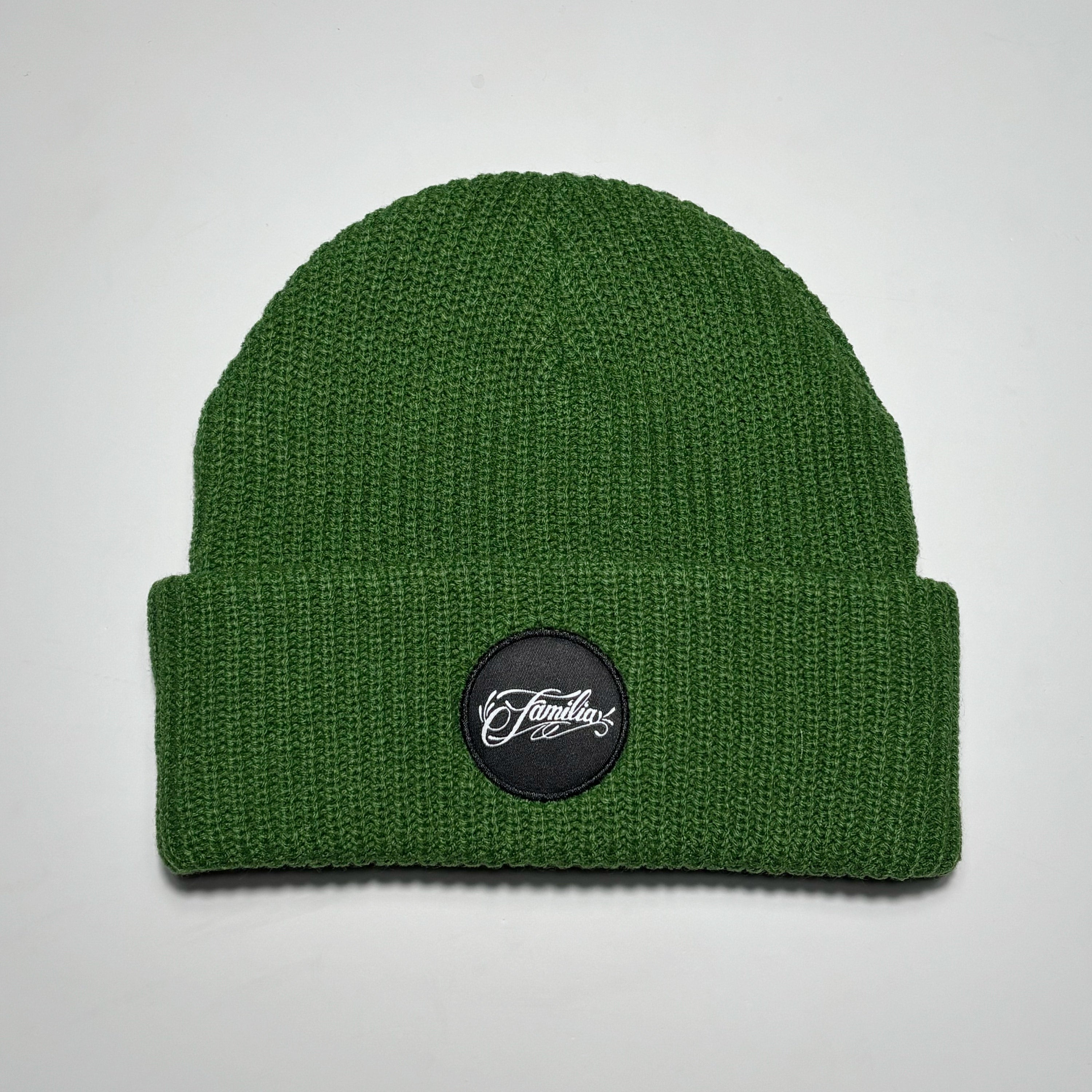 Green colored beanie with white and black familia script patch.