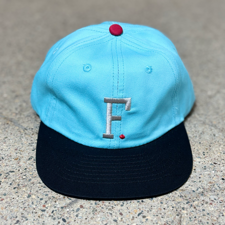 Full image of blue at with black bill. Silver embroidered "F" on crown.